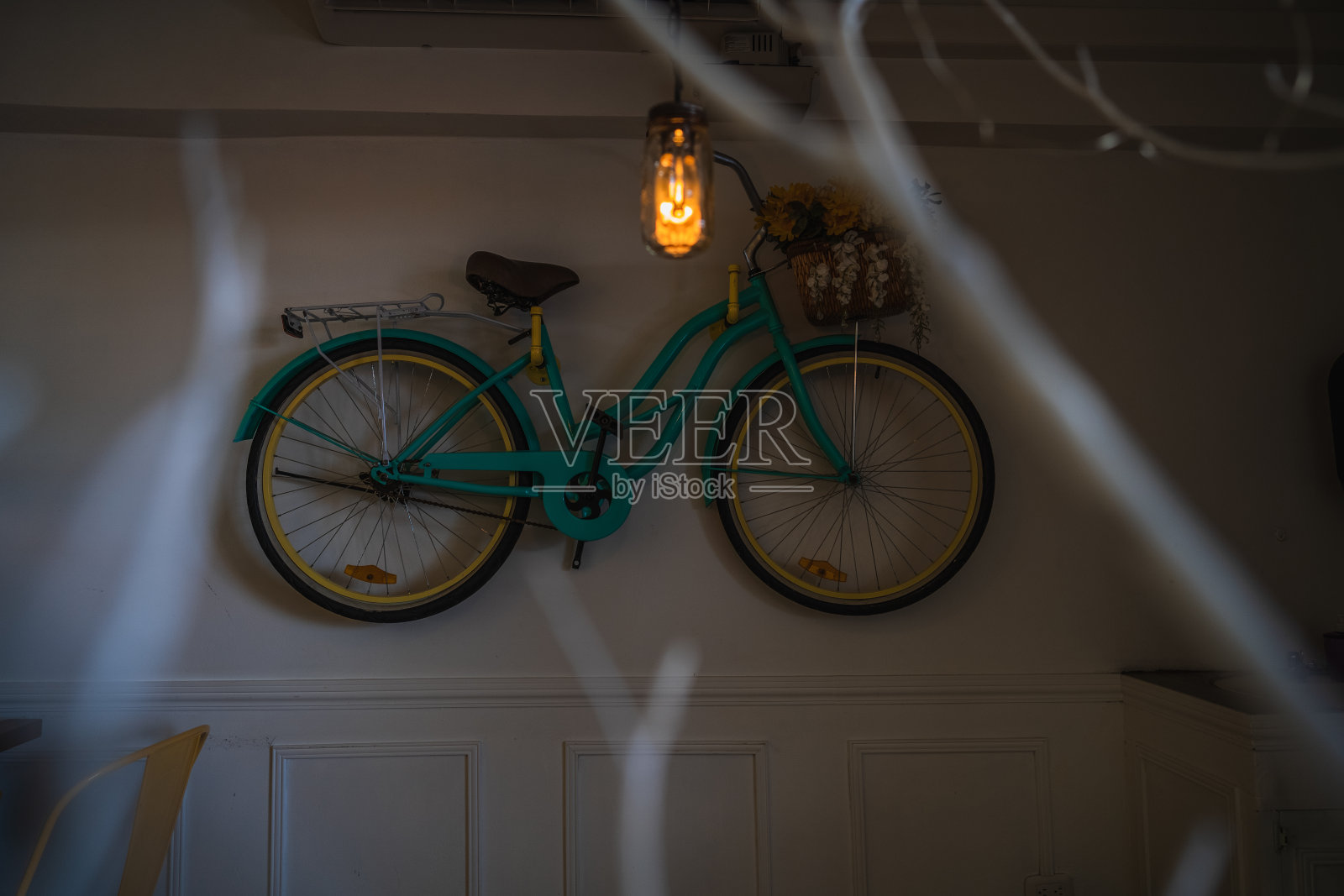 一辆老式自行车的特写，在一堵白墙前的篮子里放着一株植物照片摄影图片