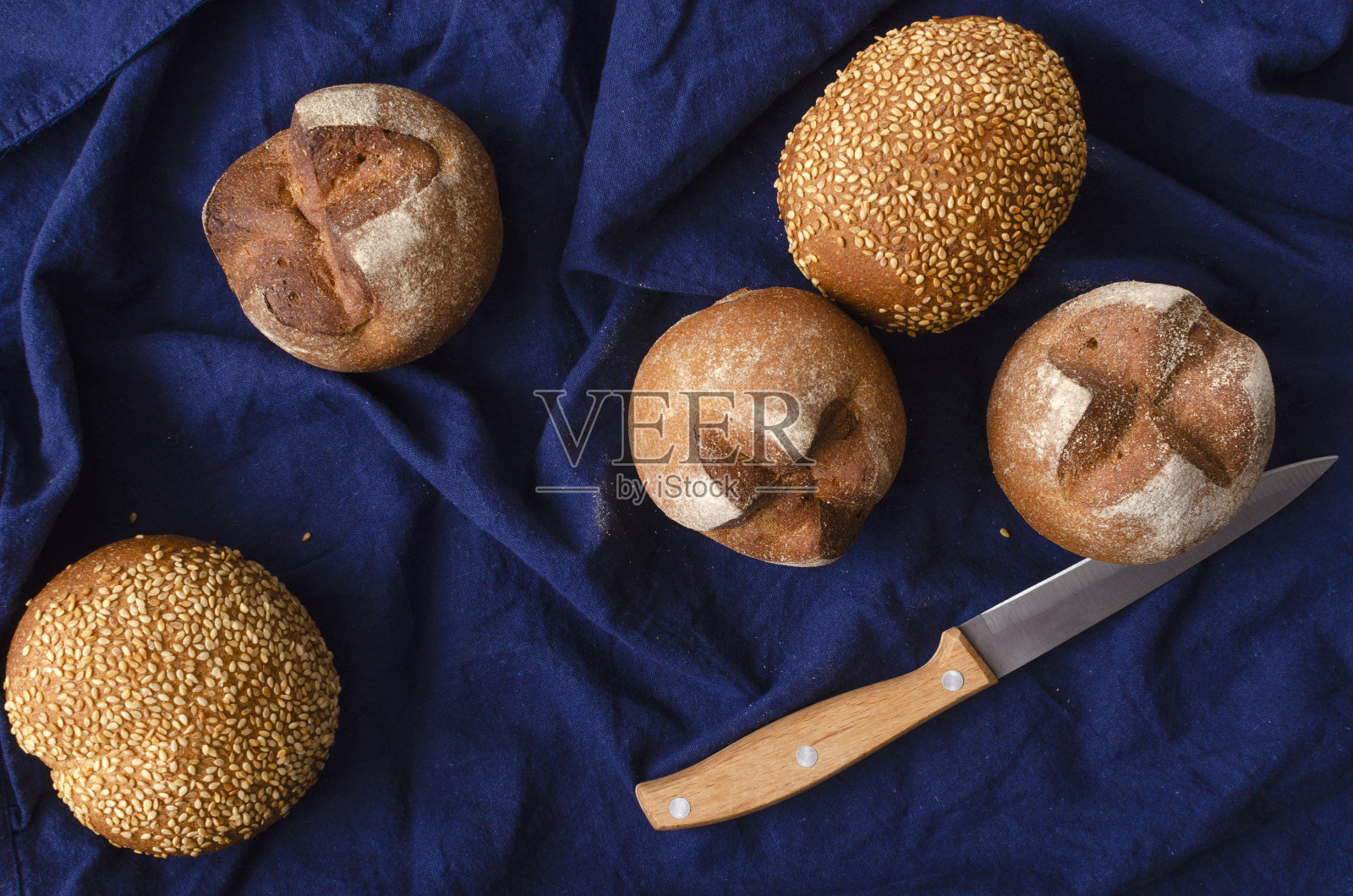 俯视图美味新鲜的面包，刀上的蓝色桌布照片摄影图片