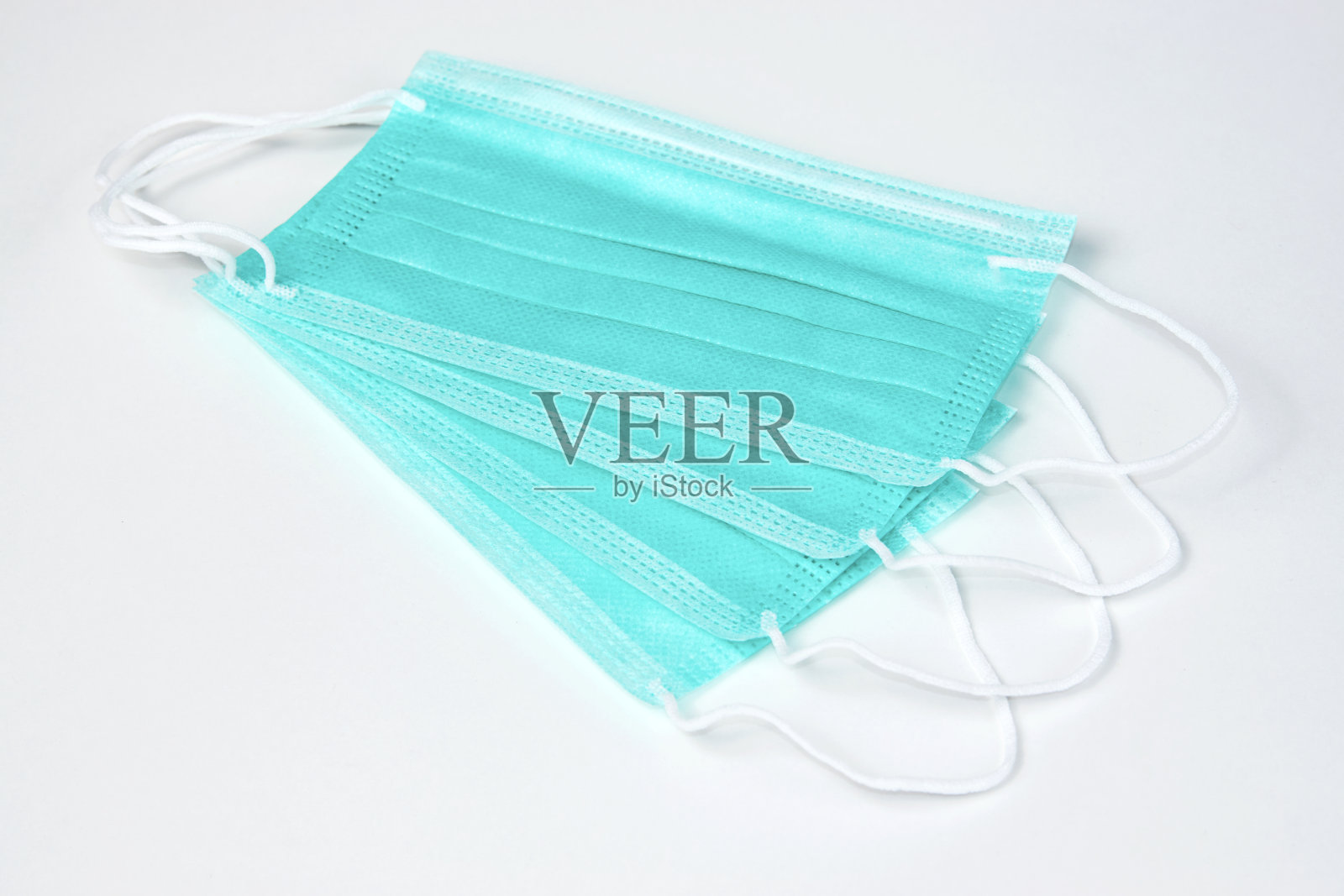 白色背景的绿色医用口罩，特写照片摄影图片