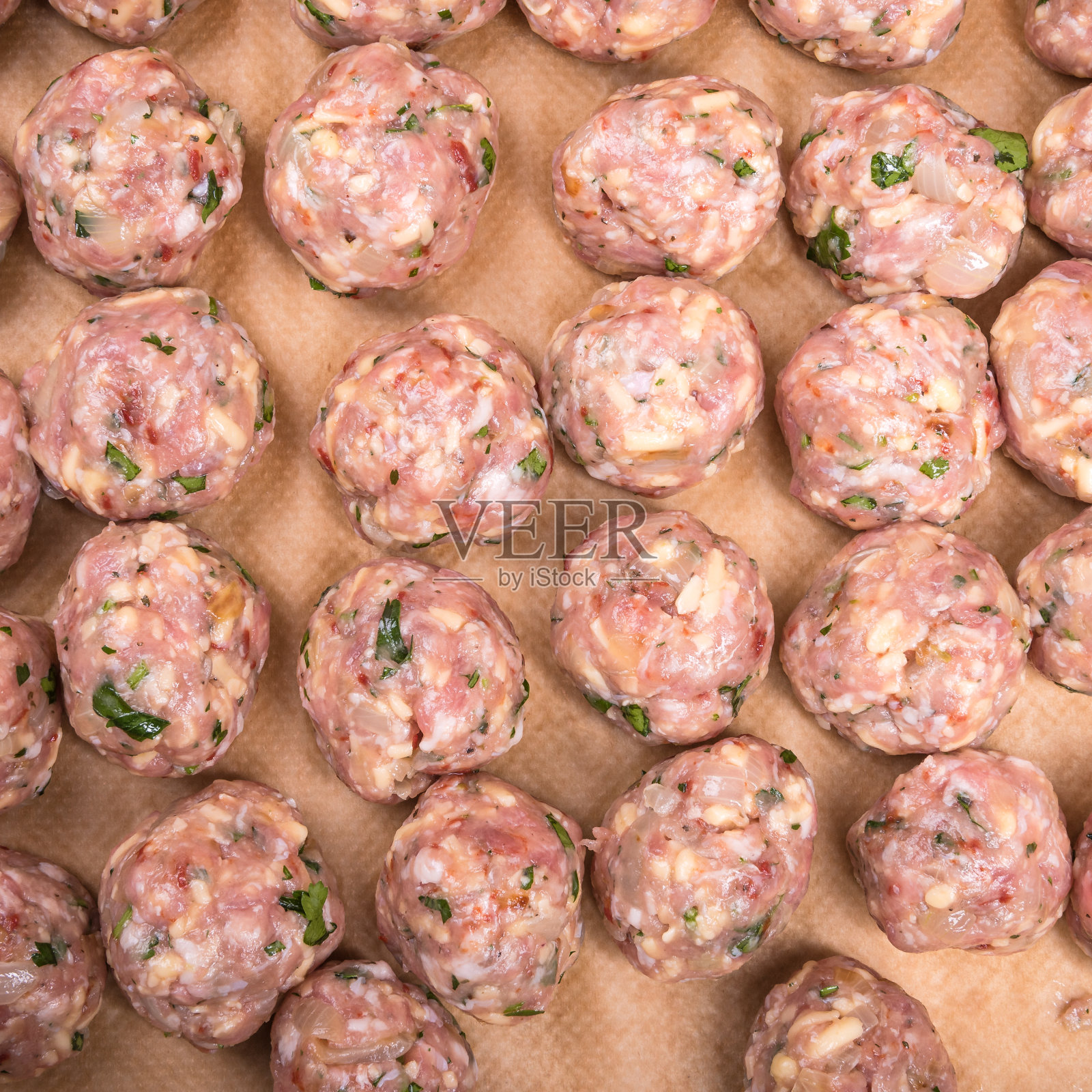 生鸡肉肉丸和奶酪在羊皮纸上烤盘在木制厨房桌子上，俯视图，特写-瑞典美食照片摄影图片