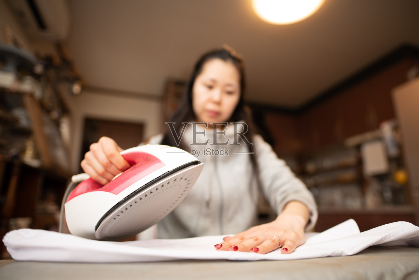 一个日本女人在房间里熨烫衣服照片摄影图片