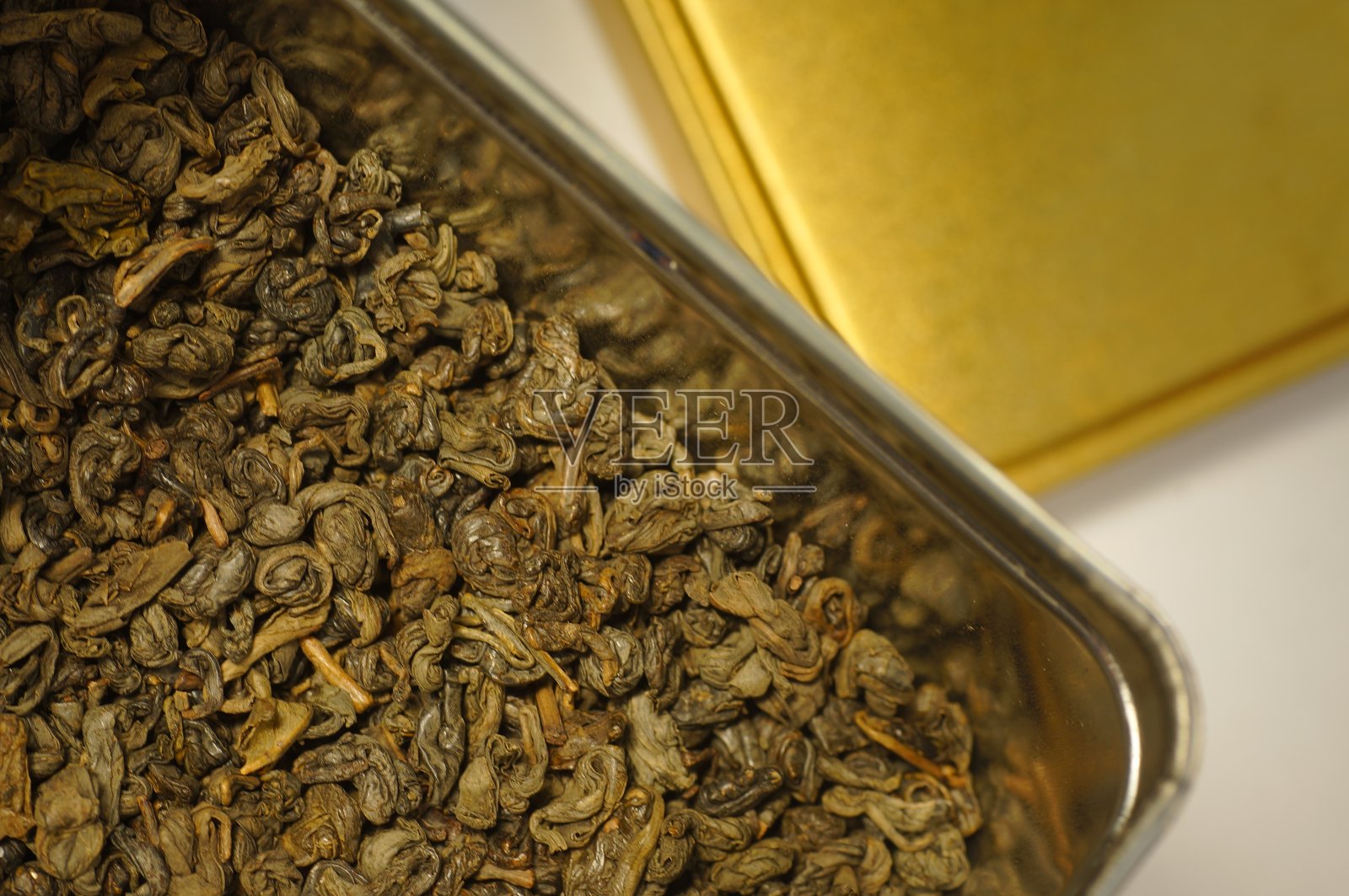 散装绿茶——装在一个金属罐里。照片摄影图片