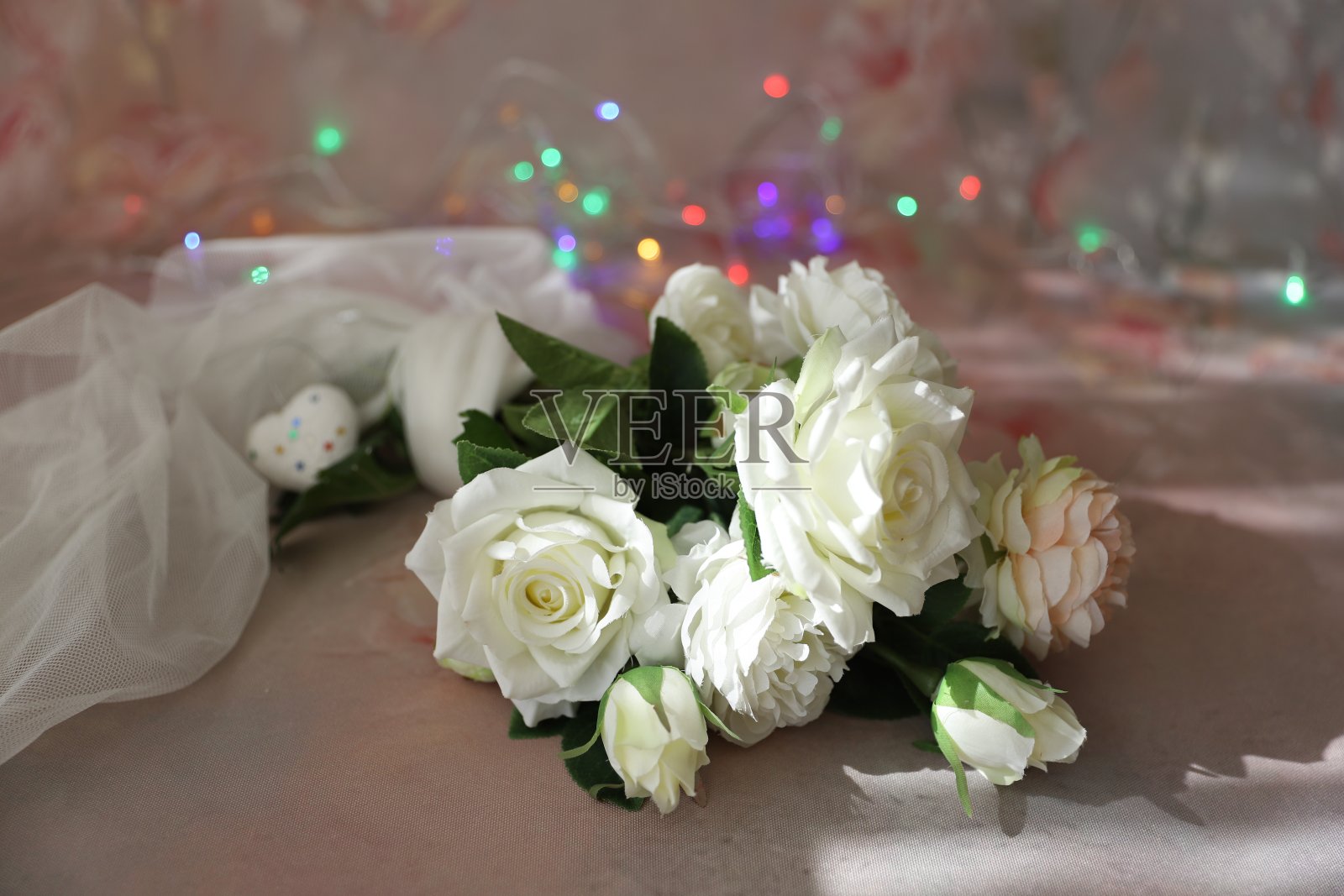 白色和粉色的玫瑰，以灯光为背景照片摄影图片