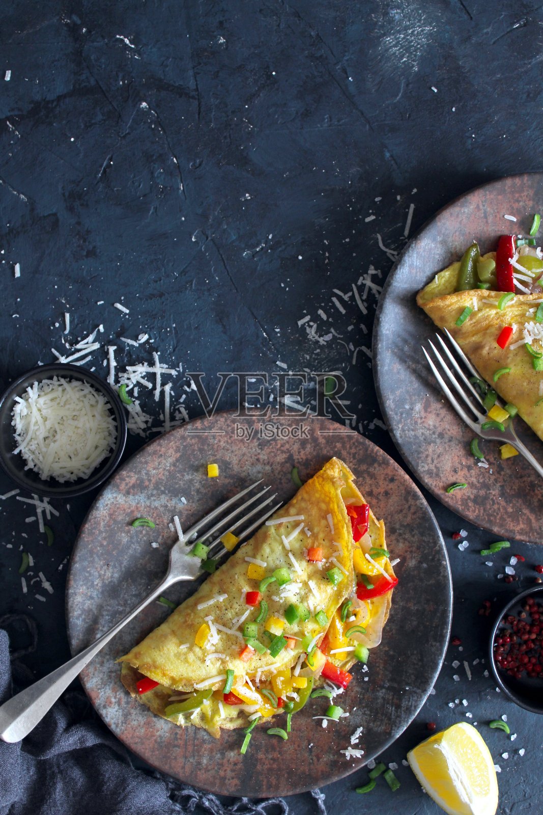 健康的早餐:黑色背景的塞满蔬菜的煎蛋卷。照片摄影图片