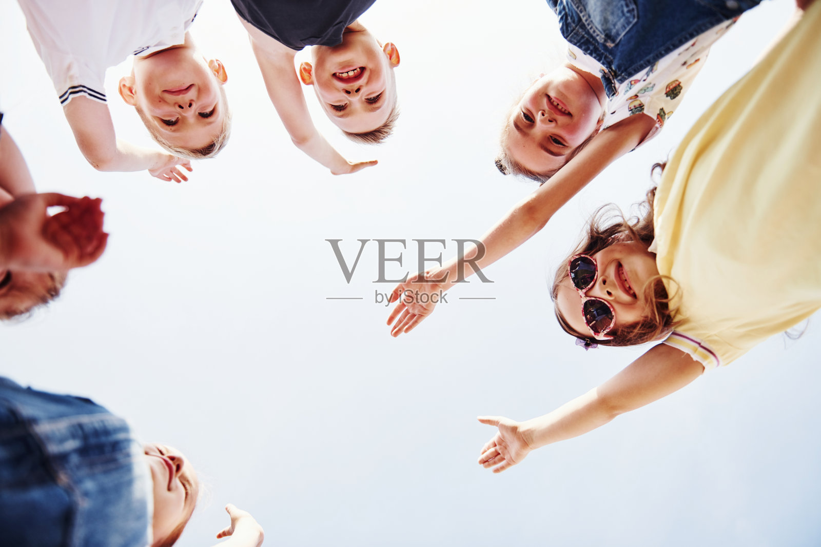 举起手来。孩子们站在一起为相机摆姿势的肖像照片摄影图片