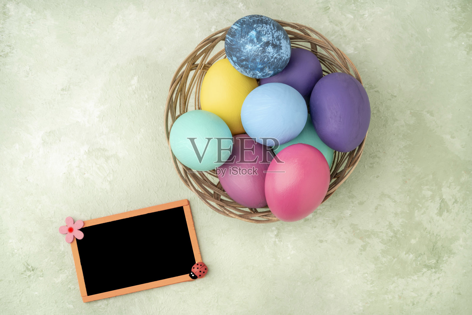 空的黑板，绿色的篮子里有复活节彩蛋照片摄影图片