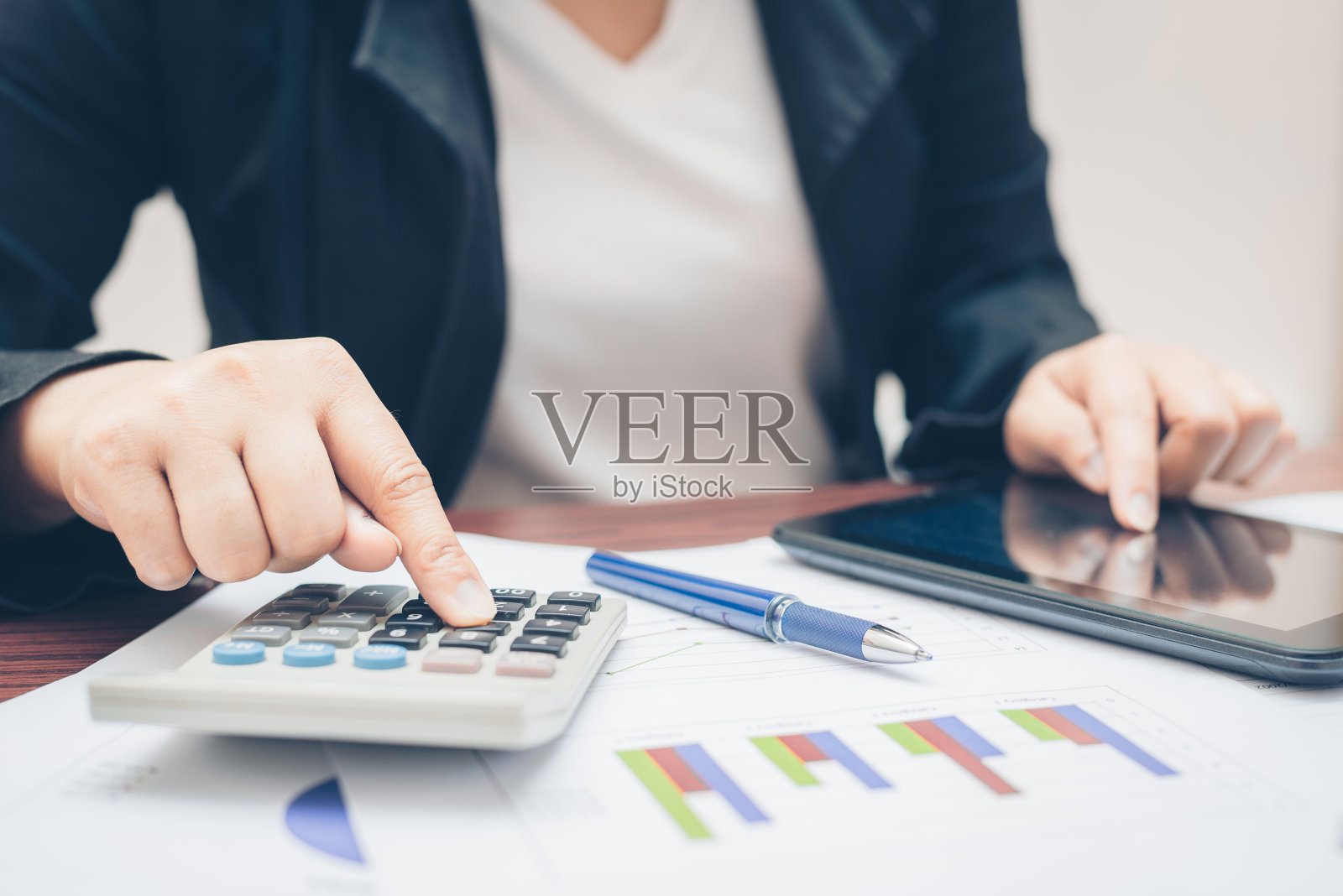 商务女性手用计算器和指向平板移动技术进行分析和预算，财务会计与增长统计图表和图表的文书工作。照片摄影图片