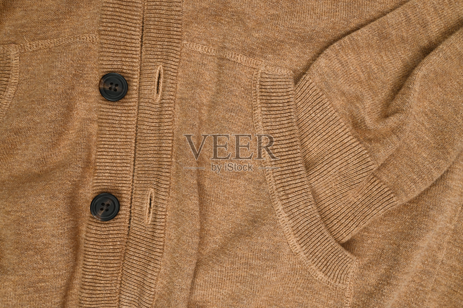 有纽扣的棕色毛衣，收起来照片摄影图片