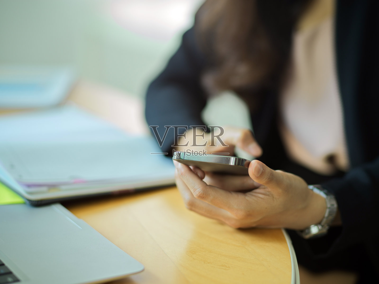 女商人在工作场所手持智能手机照片摄影图片