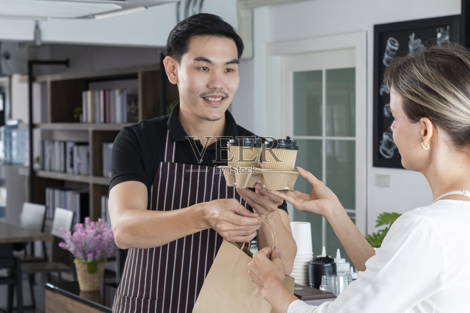 在咖啡厅为女顾客提供热饮服务。照片摄影图片
