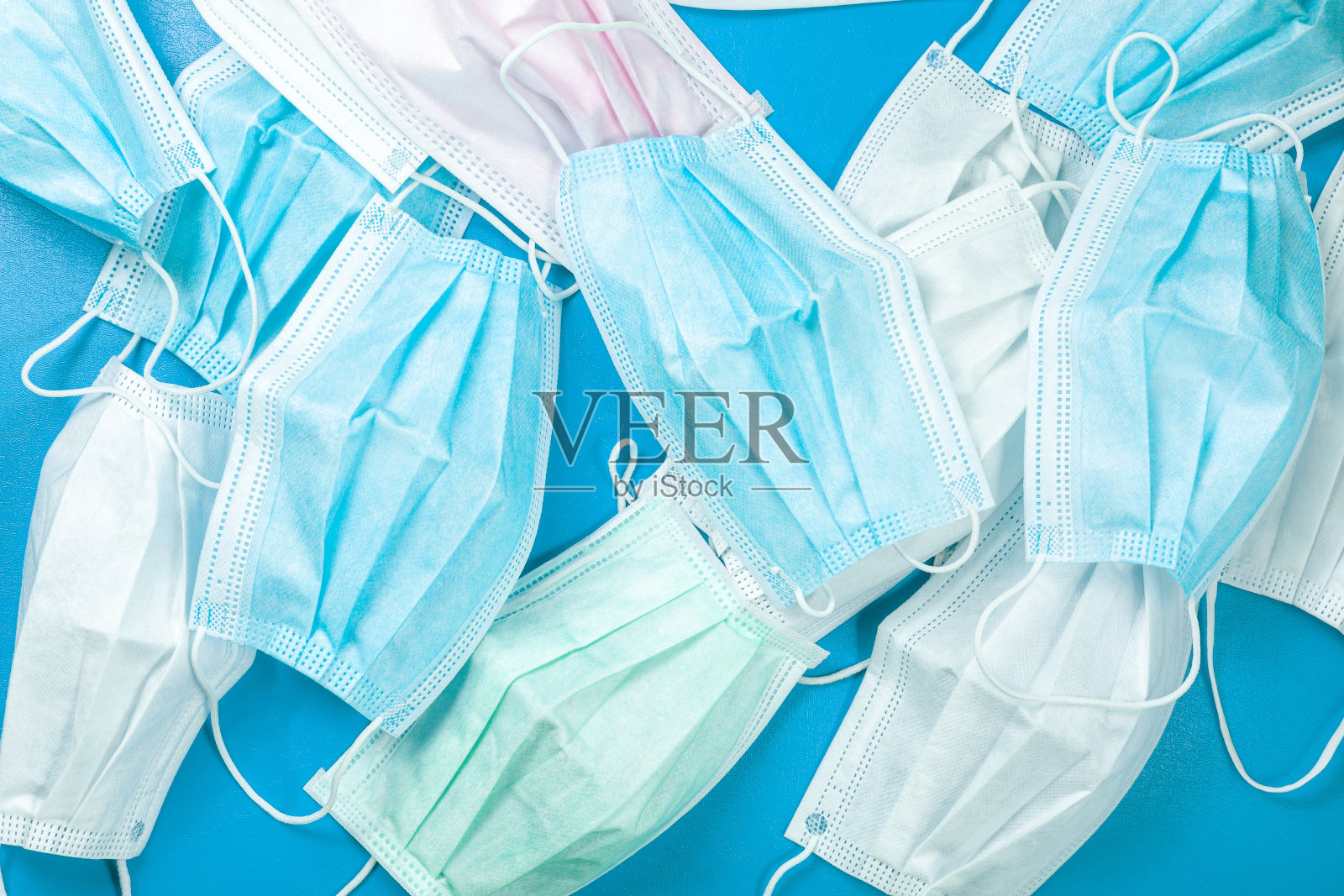 在垃圾桶中使用卫生口罩、传染性废物，通过分离受感染废物防止covid-19病毒。隔离已经结束了面罩的利用率。一次性使用面膜照片摄影图片