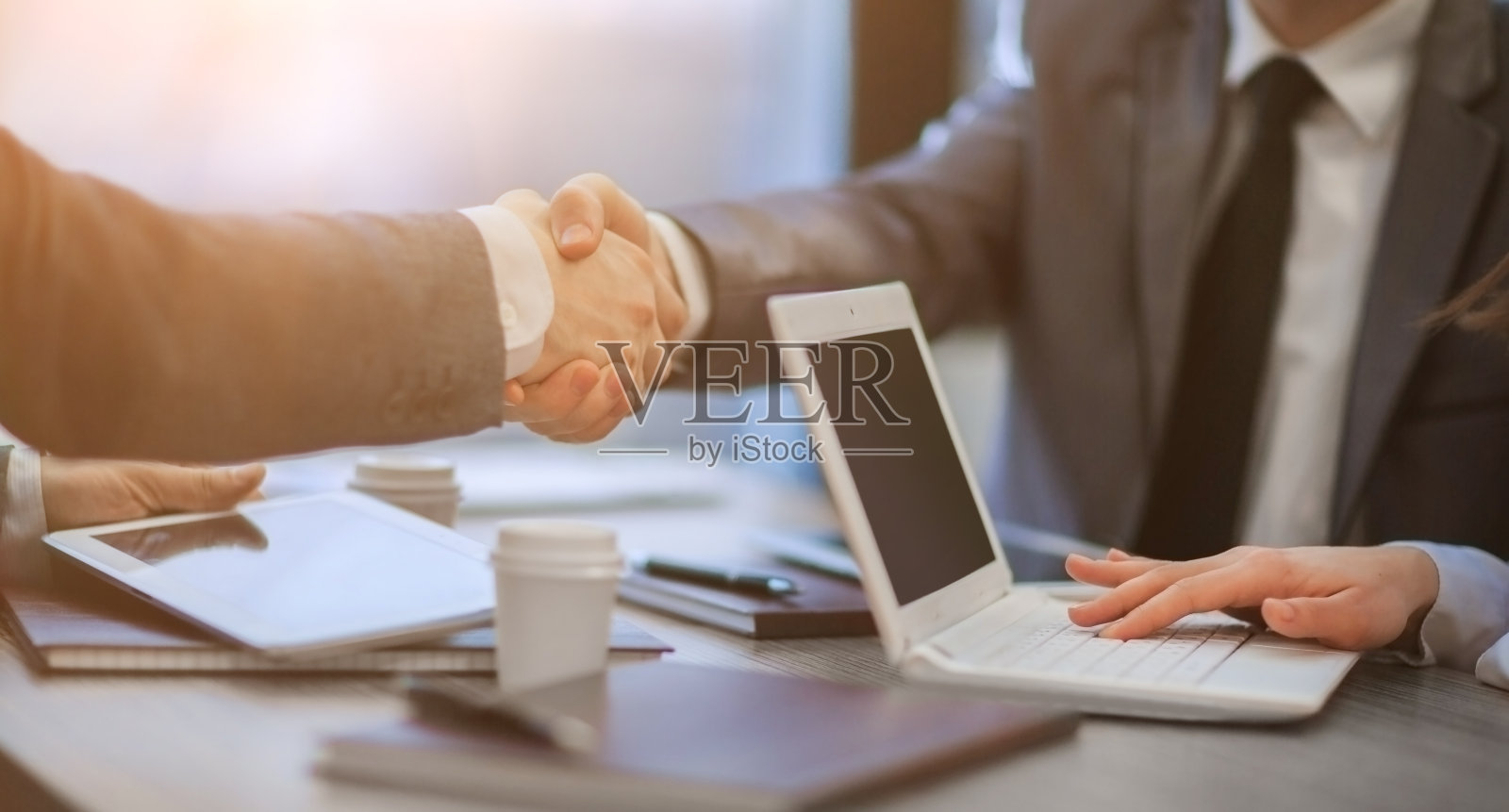 同事们在办公桌前握手。近距离照片摄影图片