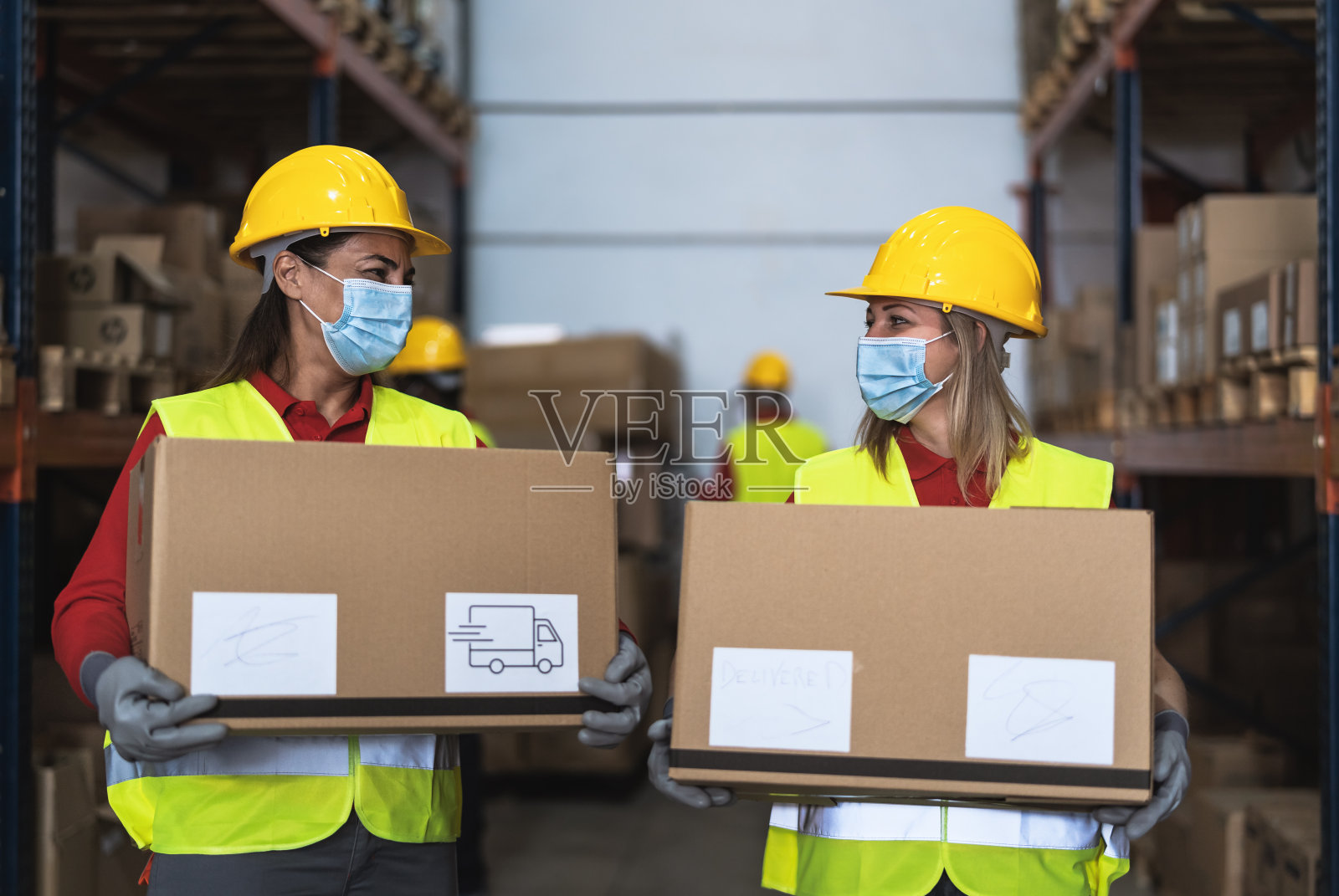 疫情期间仓库团队工作，戴口罩装载包裹，物流工业照片摄影图片
