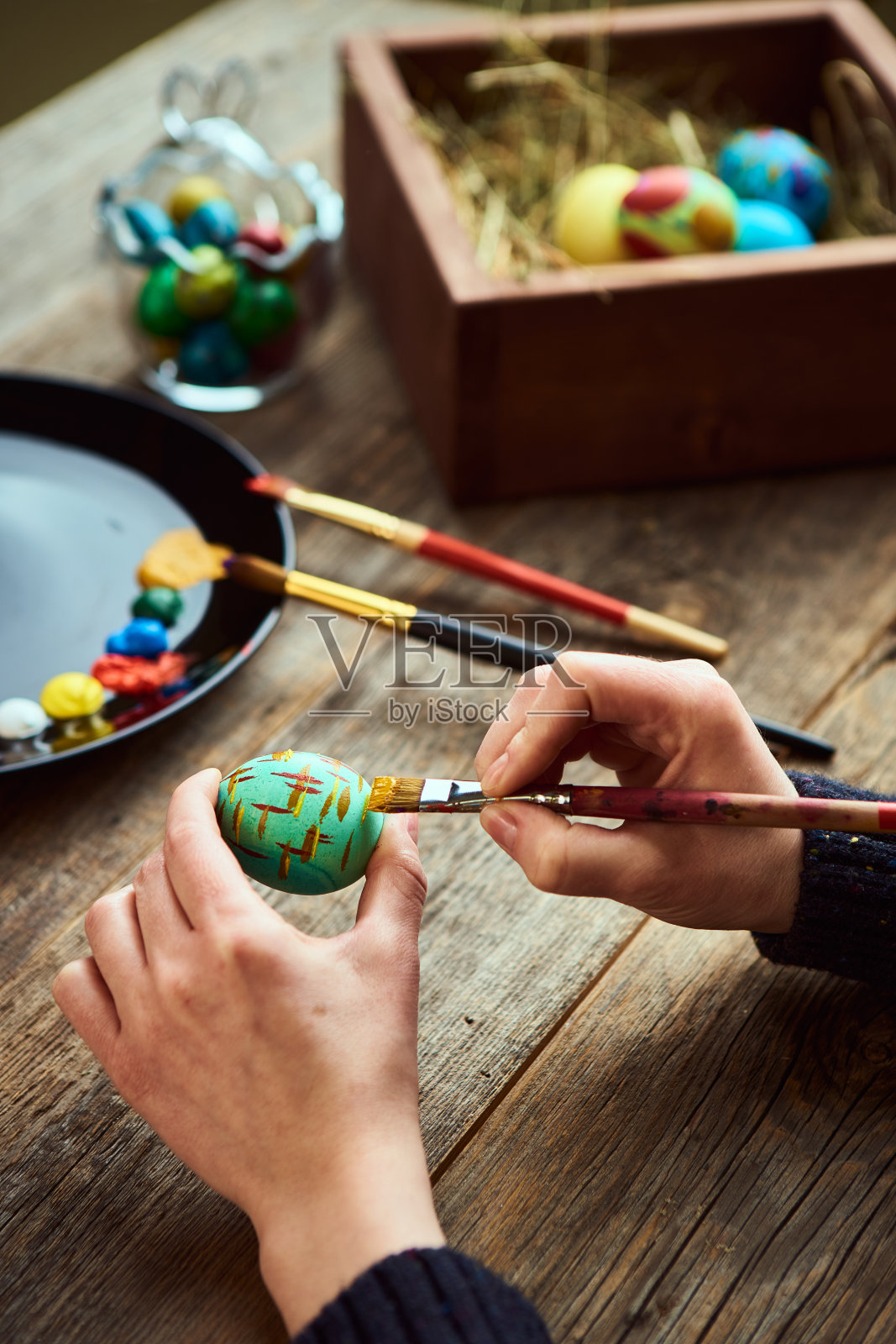女性准备宗教节日复活节，用画笔染蛋。艺术家的工作室照片摄影图片