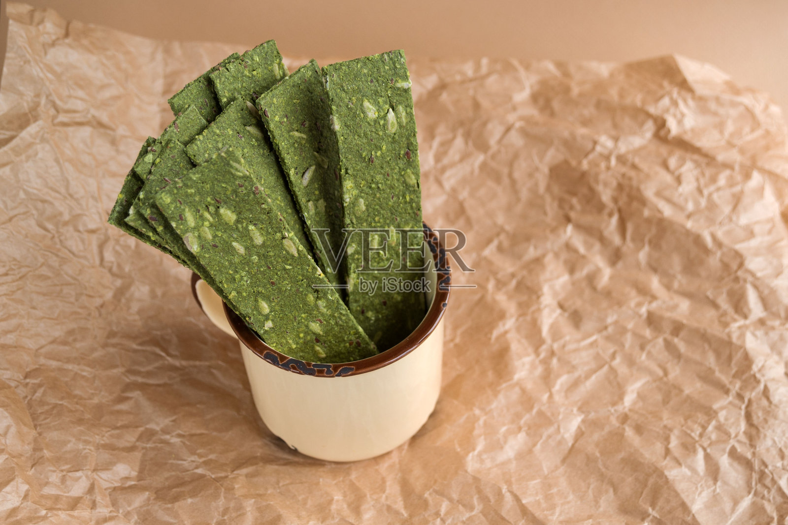 素食片配海草。牛皮纸上涂有螺旋藻、亚麻籽、生姜和芥末的脆片。海洋multi-snacks。照片摄影图片