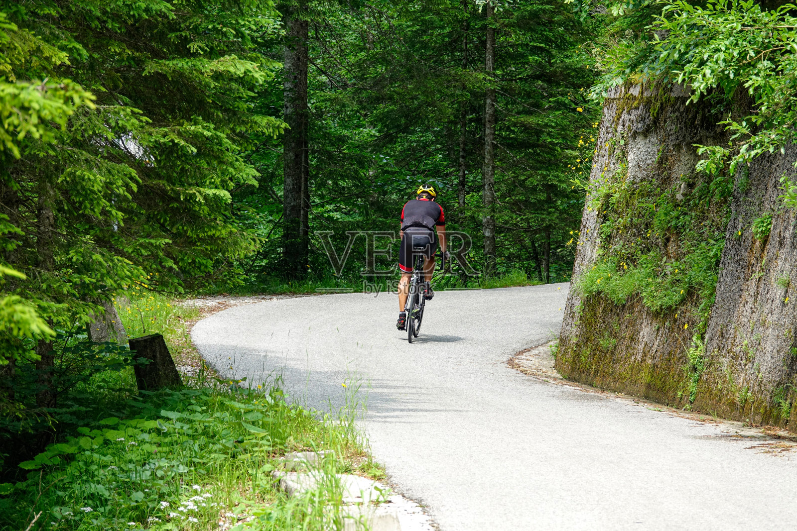 一个在朱利安阿尔卑斯山度假的健康男子骑着自行车沿着一条风景优美的路线骑行。照片摄影图片