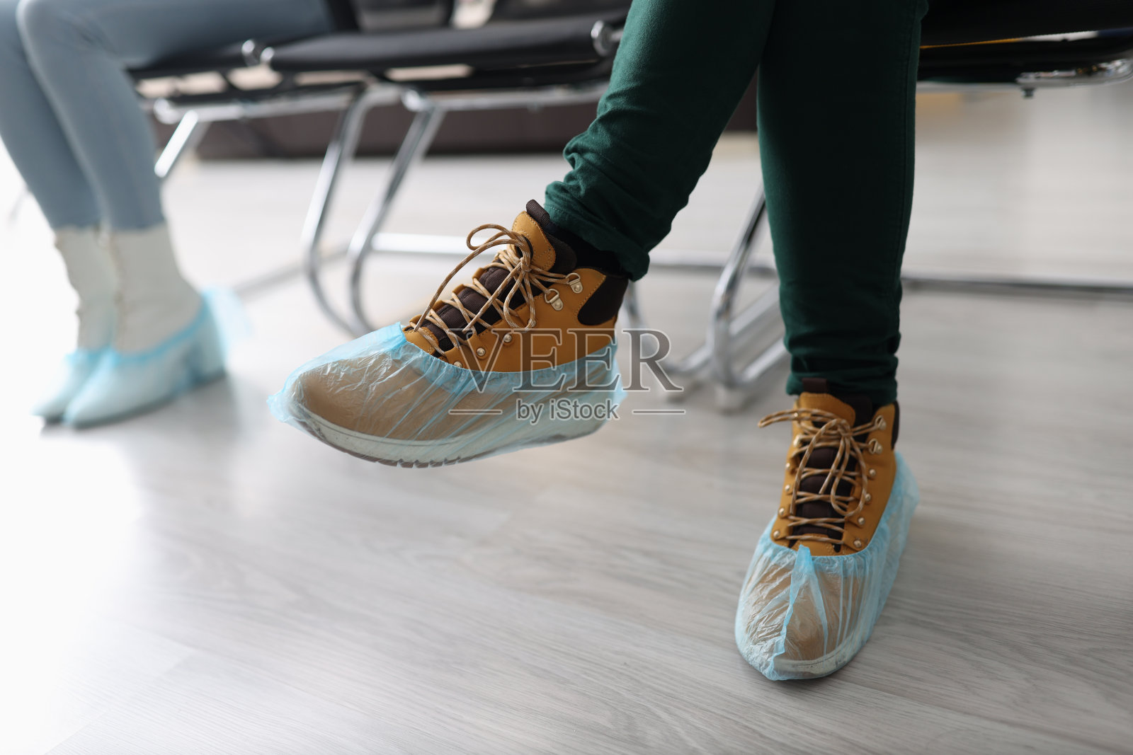 女人坐在排队与鞋套在他们的脚近距离照片摄影图片