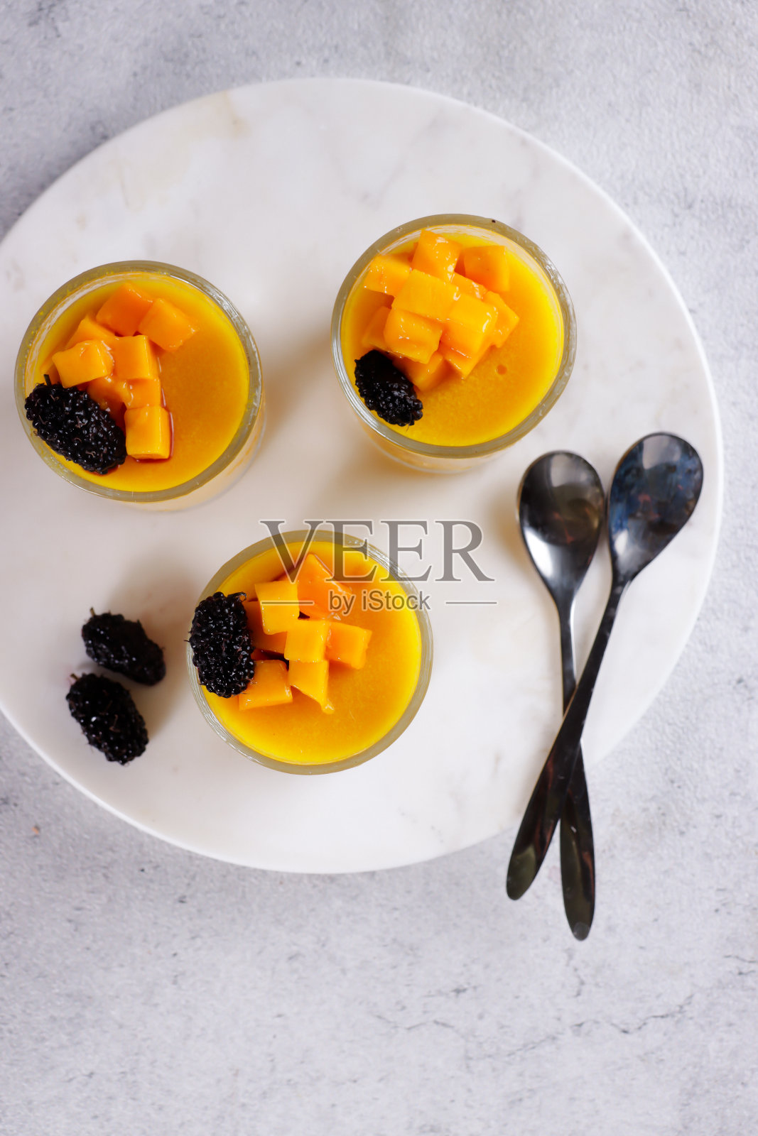 布丁芒果或自制的新鲜芒果果酱，上面点缀着芒果片和黑莓照片摄影图片