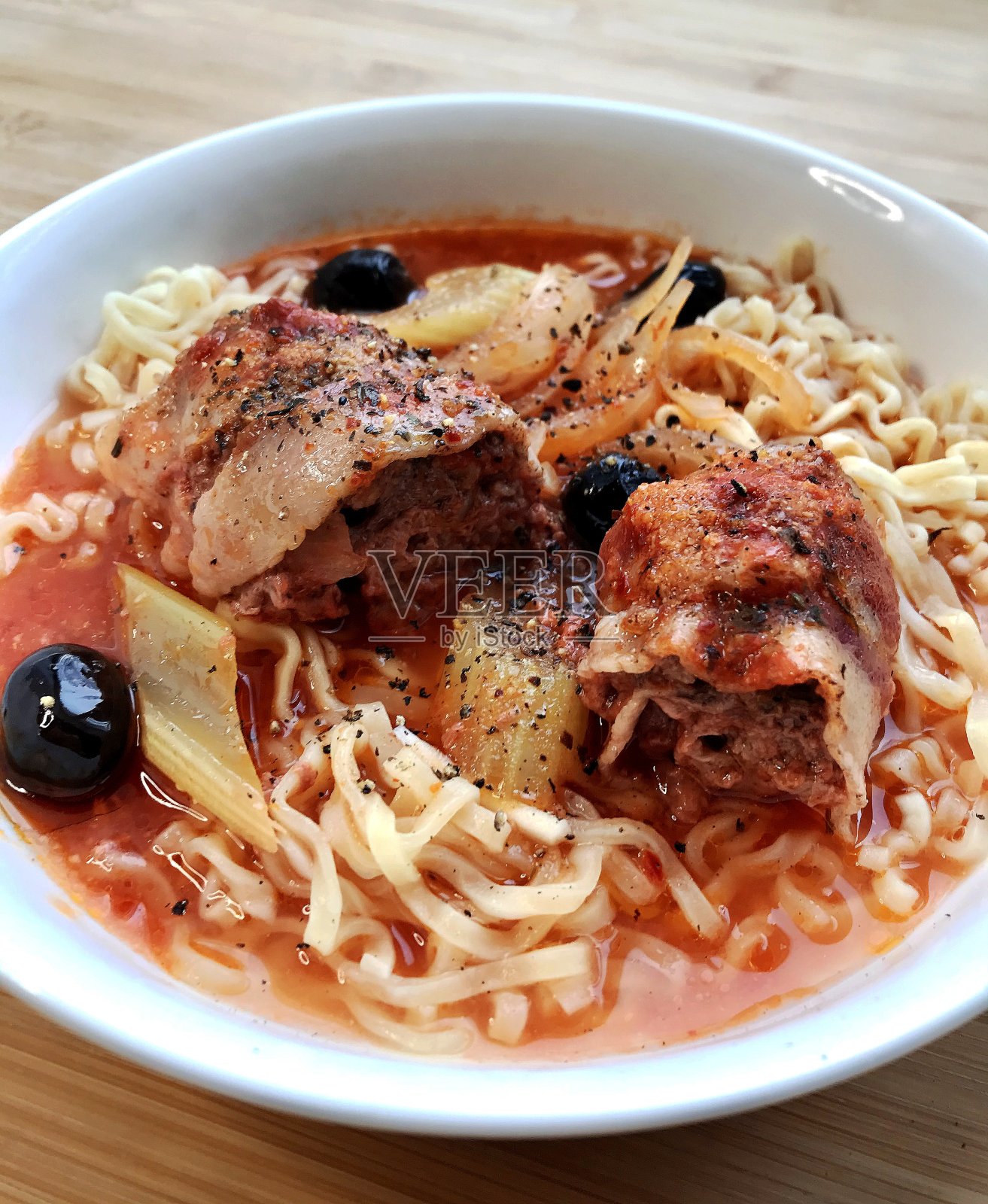 桌上有白色的盘子，里面有肉和蔬菜面条。照片摄影图片