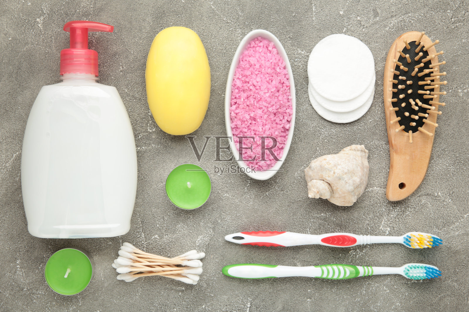 灰色背景上的沐浴产品。带有芳香盐、肥皂和其他盥洗用品的沐浴露。照片摄影图片