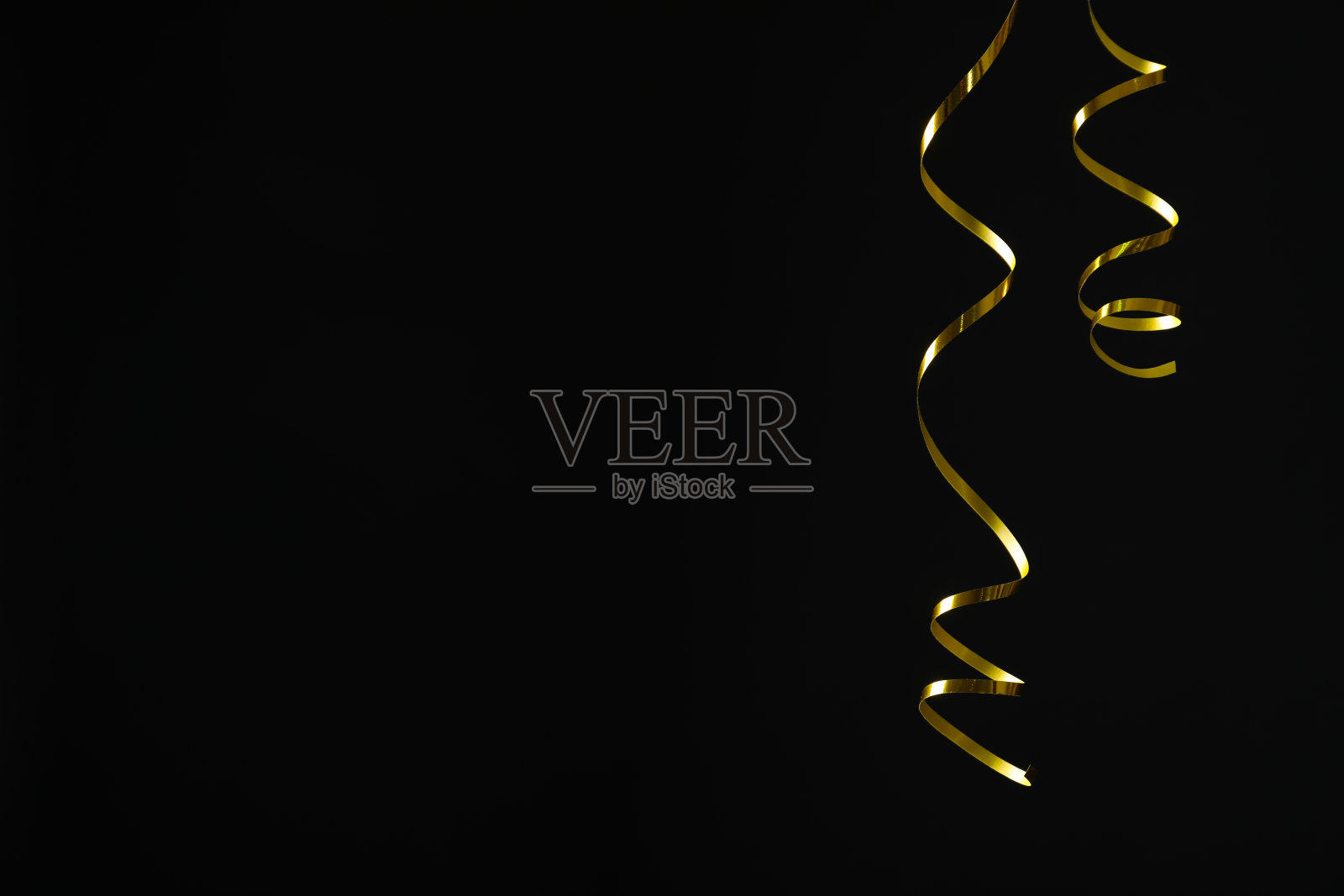 黑色背景上闪闪发光的金色蛇纹石流光。空间的文本照片摄影图片