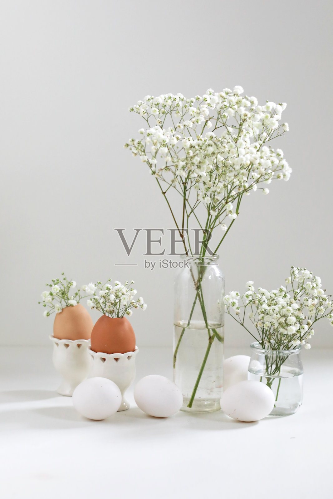 花束与白色的花，松柏草和鸡蛋在光的背景。副本的空间。复活节的概念。照片摄影图片
