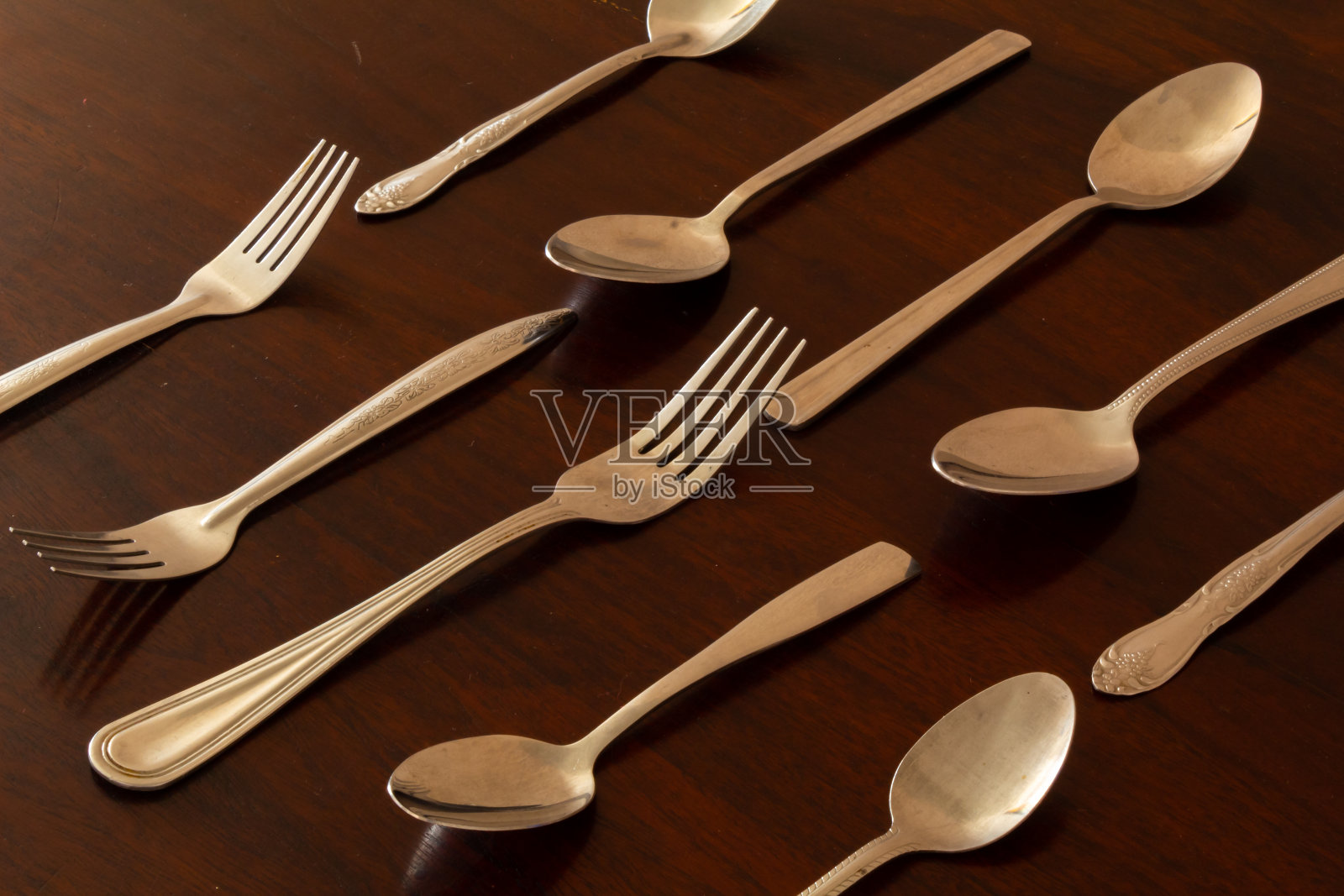 闪亮的勺子和叉子在黑色的背景上照片摄影图片