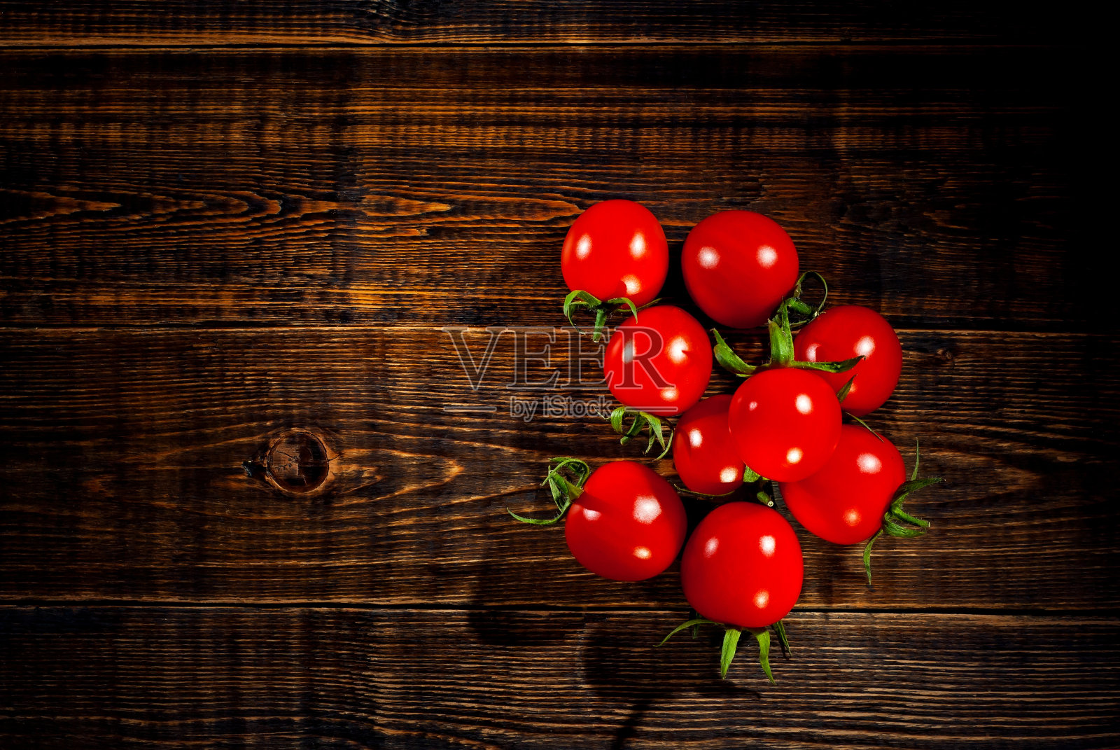 把西红柿放在木板上。黑色背景上的蔬菜。作为一种艺术效果来对比戏剧性的光线。复制空间和自由空间的文本附近西红柿。照片摄影图片