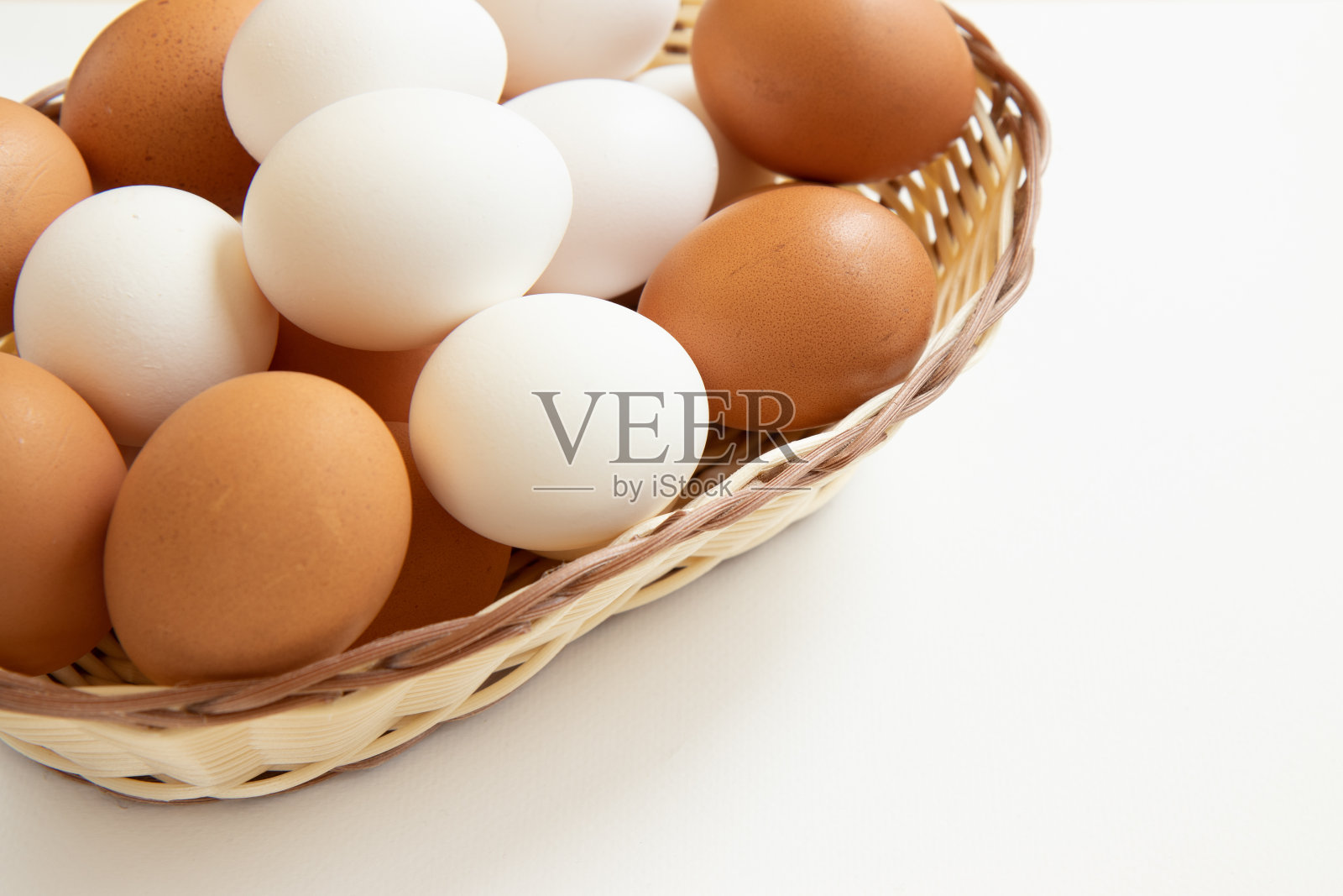 白底柳条篮子里的鸡蛋。照片摄影图片