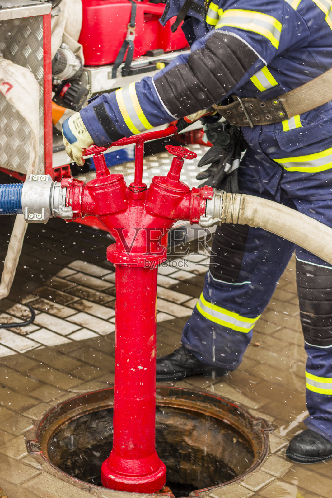 消火栓和消防队员拧水龙头照片摄影图片