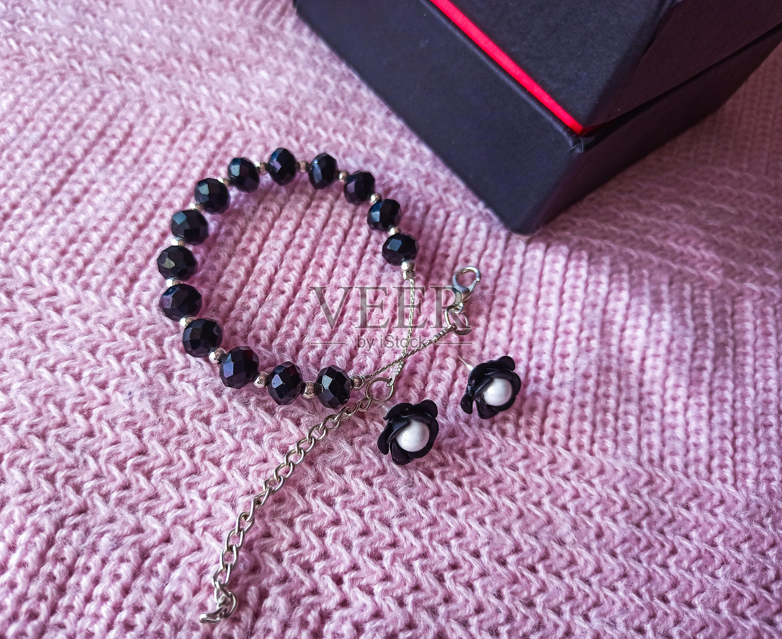 黑色串珠手镯和礼盒的照片。照片摄影图片