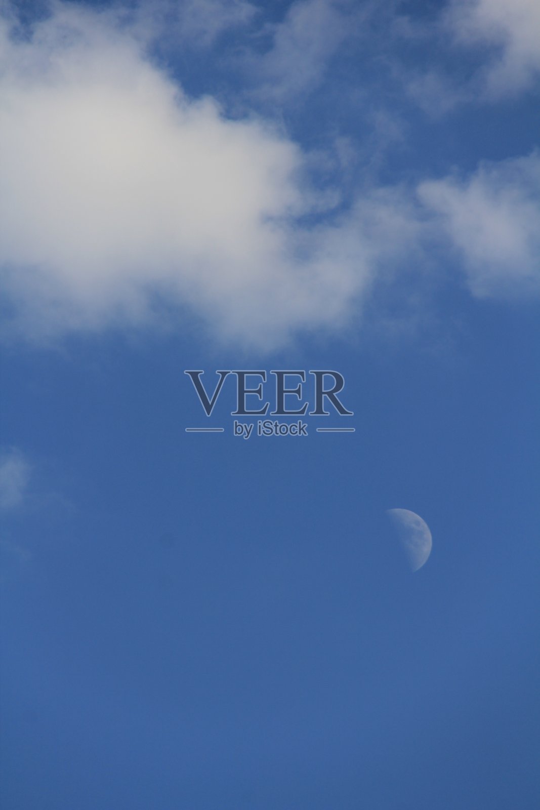 夜晚的月亮与明亮和黑暗的云在蓝色的背景。照片摄影图片