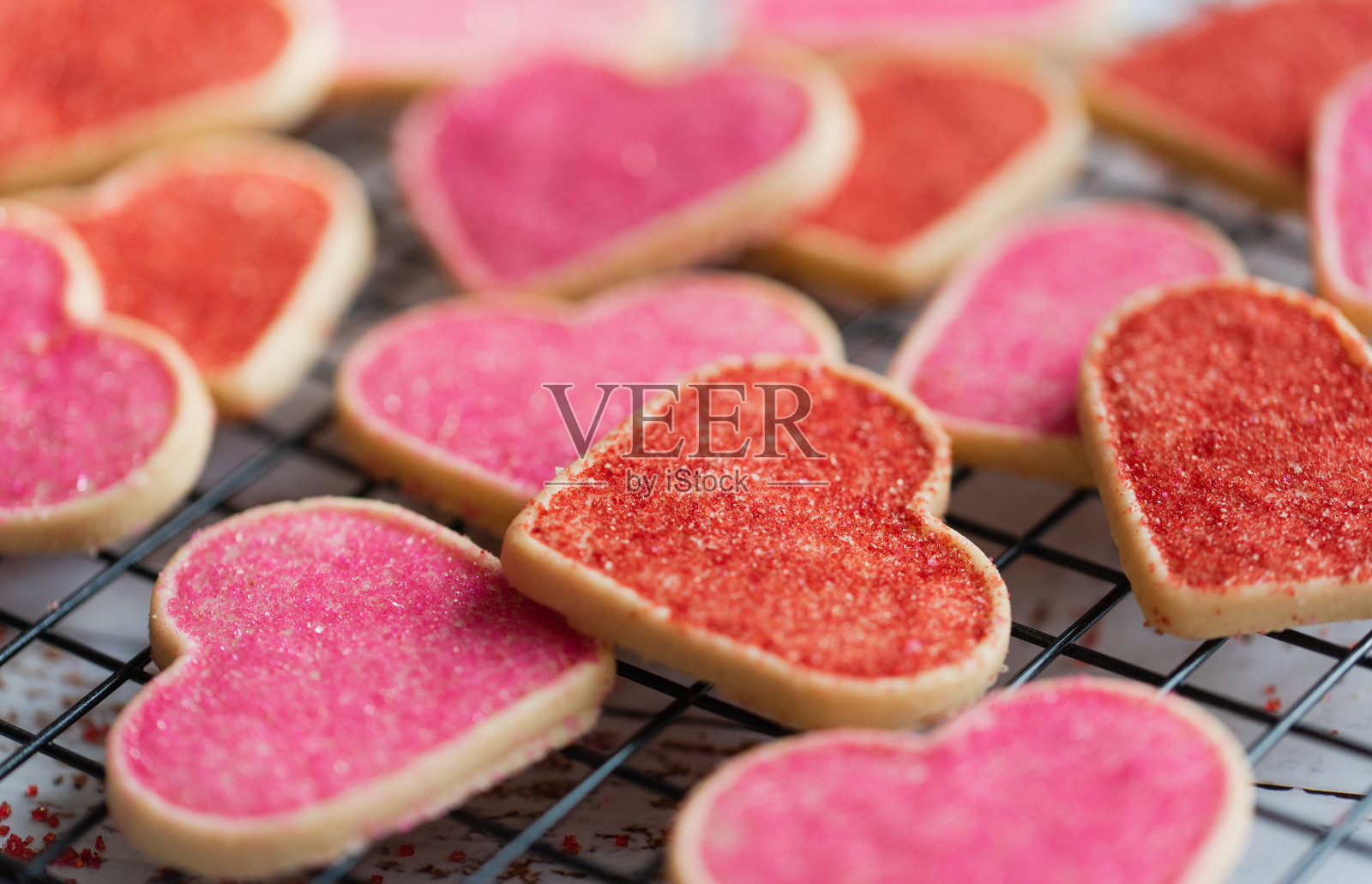 近距离观看许多装饰心形的饼干在冷却架上。照片摄影图片
