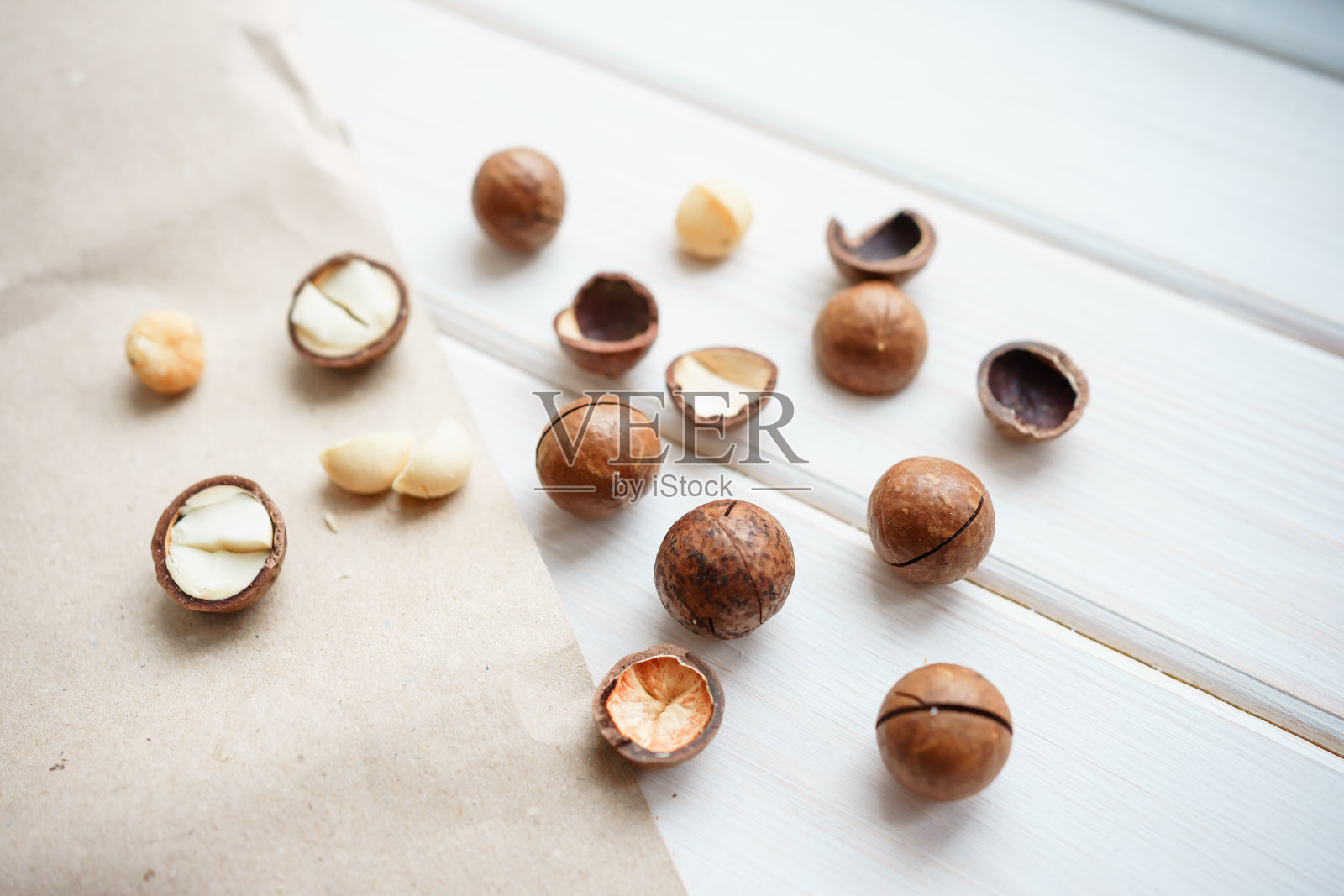 白色木质背景上的澳洲坚果照片摄影图片