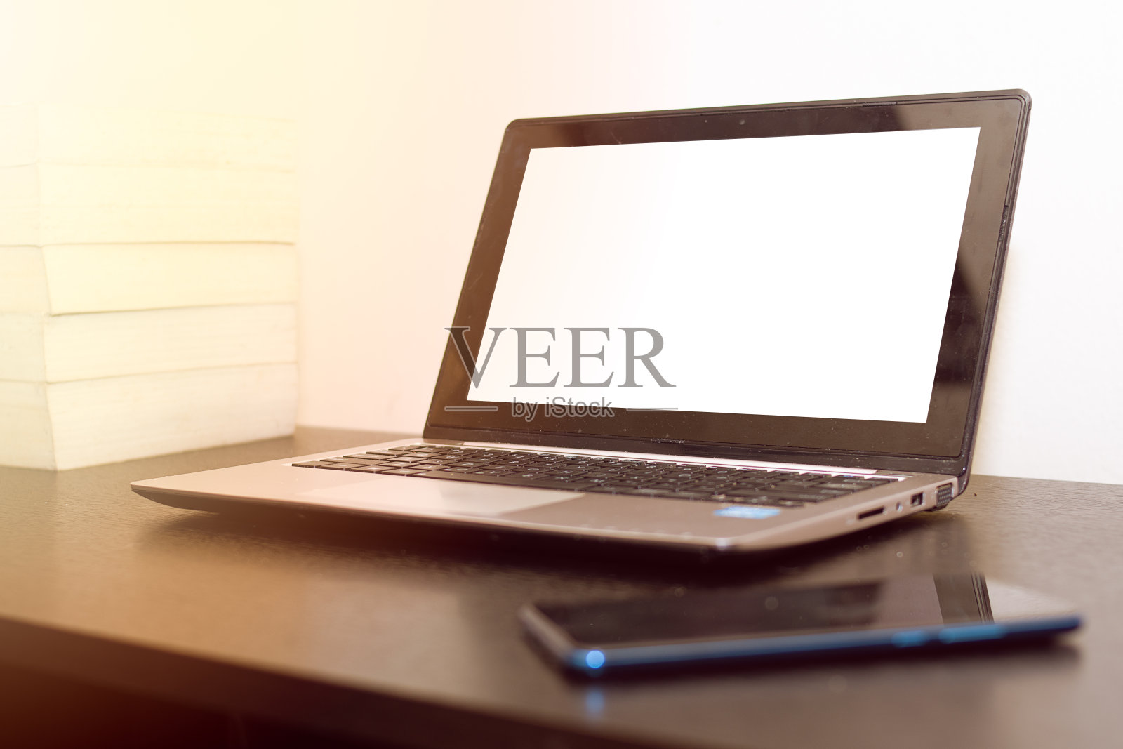 银色笔记本，黑色手机旁边照片摄影图片