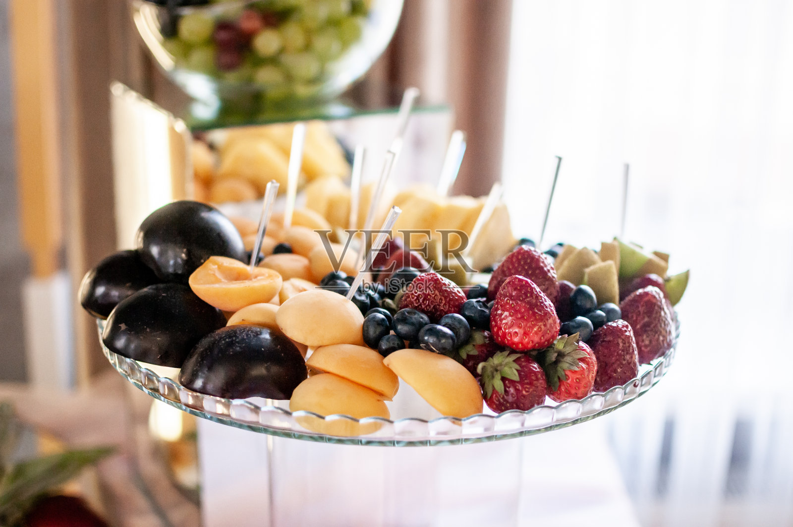 在婚宴上切水果。西瓜、葡萄、草莓、橘子、李子、梨、丁哈、桃子、猕猴桃、菠萝、柿子、苹果照片摄影图片