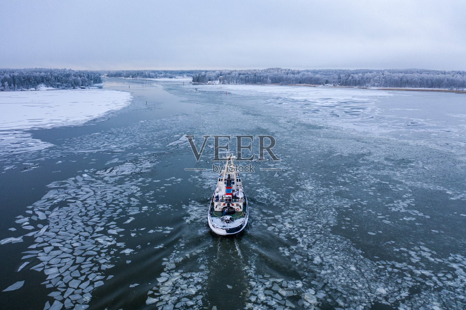 一艘拖船在冰中穿行照片摄影图片