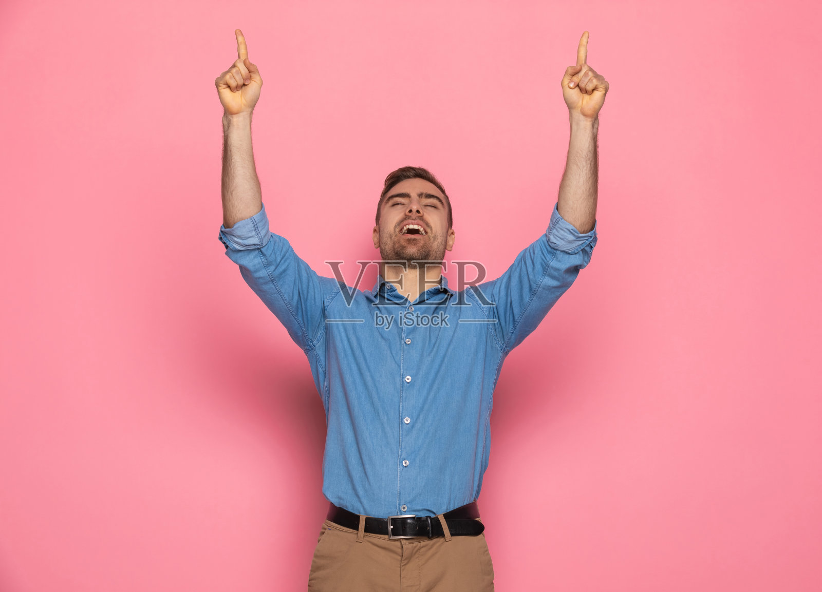 一个穿着牛仔衬衫的年轻人在空中指指点点照片摄影图片