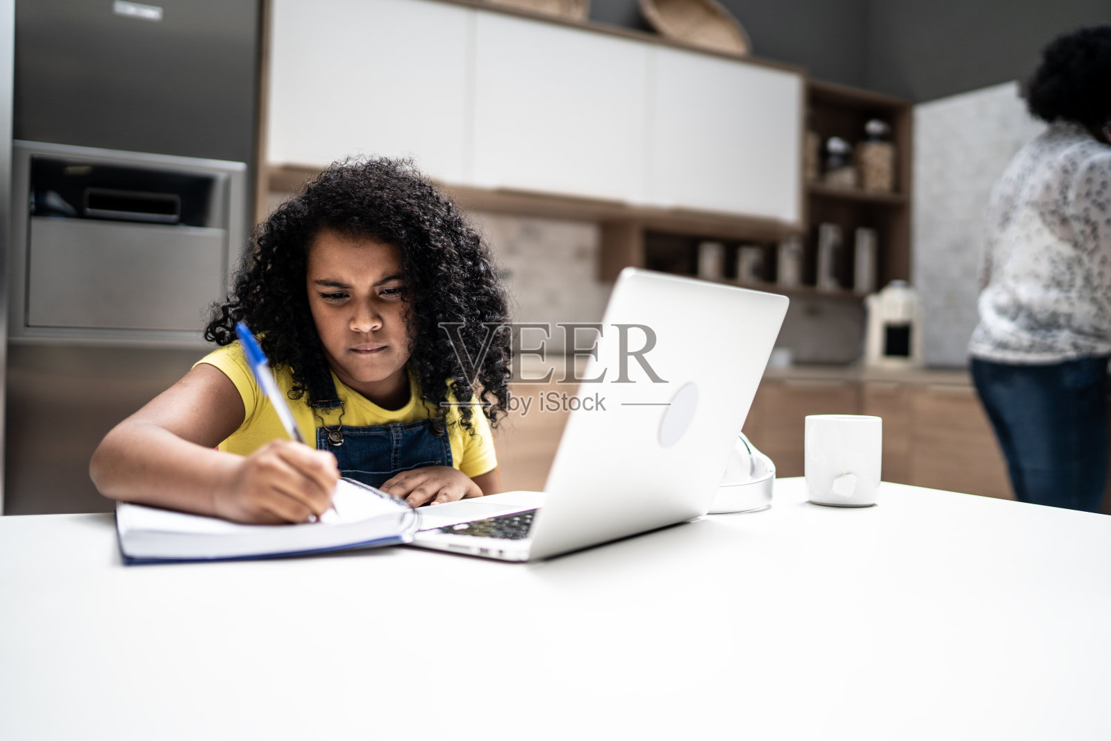 女孩在家里用笔记本电脑做作业照片摄影图片