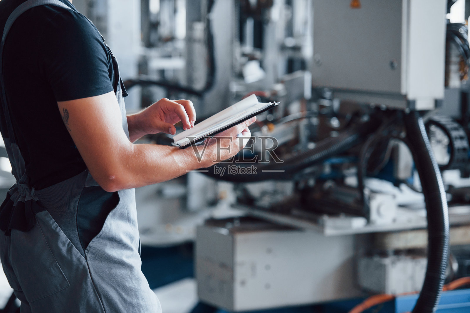 翻页记事本。工厂内的工业工人。年轻的技术员照片摄影图片