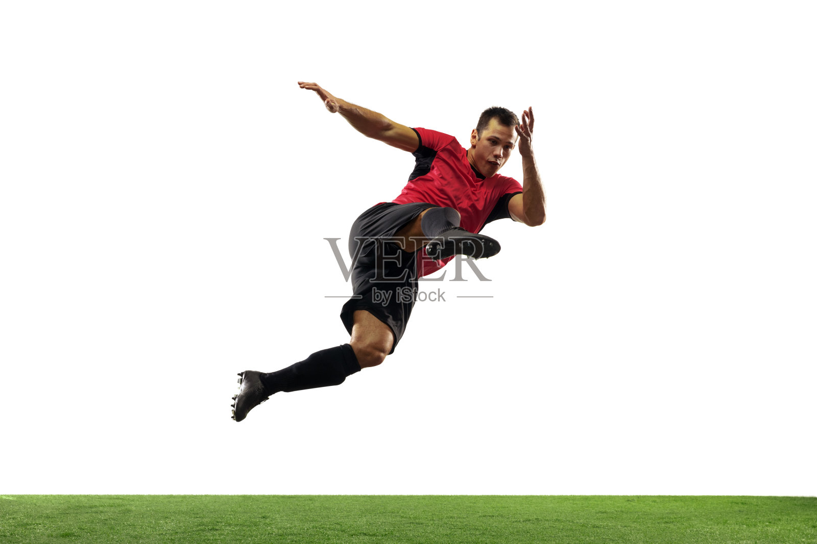 年轻的足球运动员，在行动中的足球运动员，运动孤立在白色的背景。运动、运动、能量和动态的概念。照片摄影图片