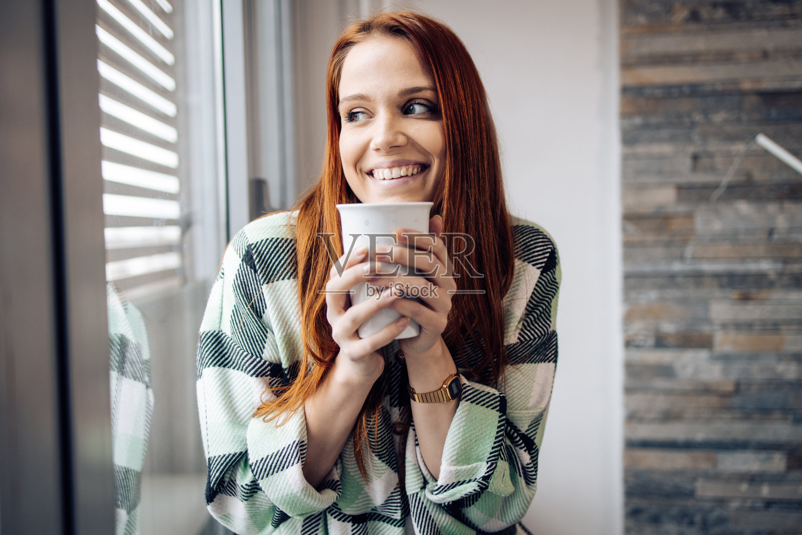 一个可爱的红发女孩在窗边享受清晨咖啡的肖像照片摄影图片