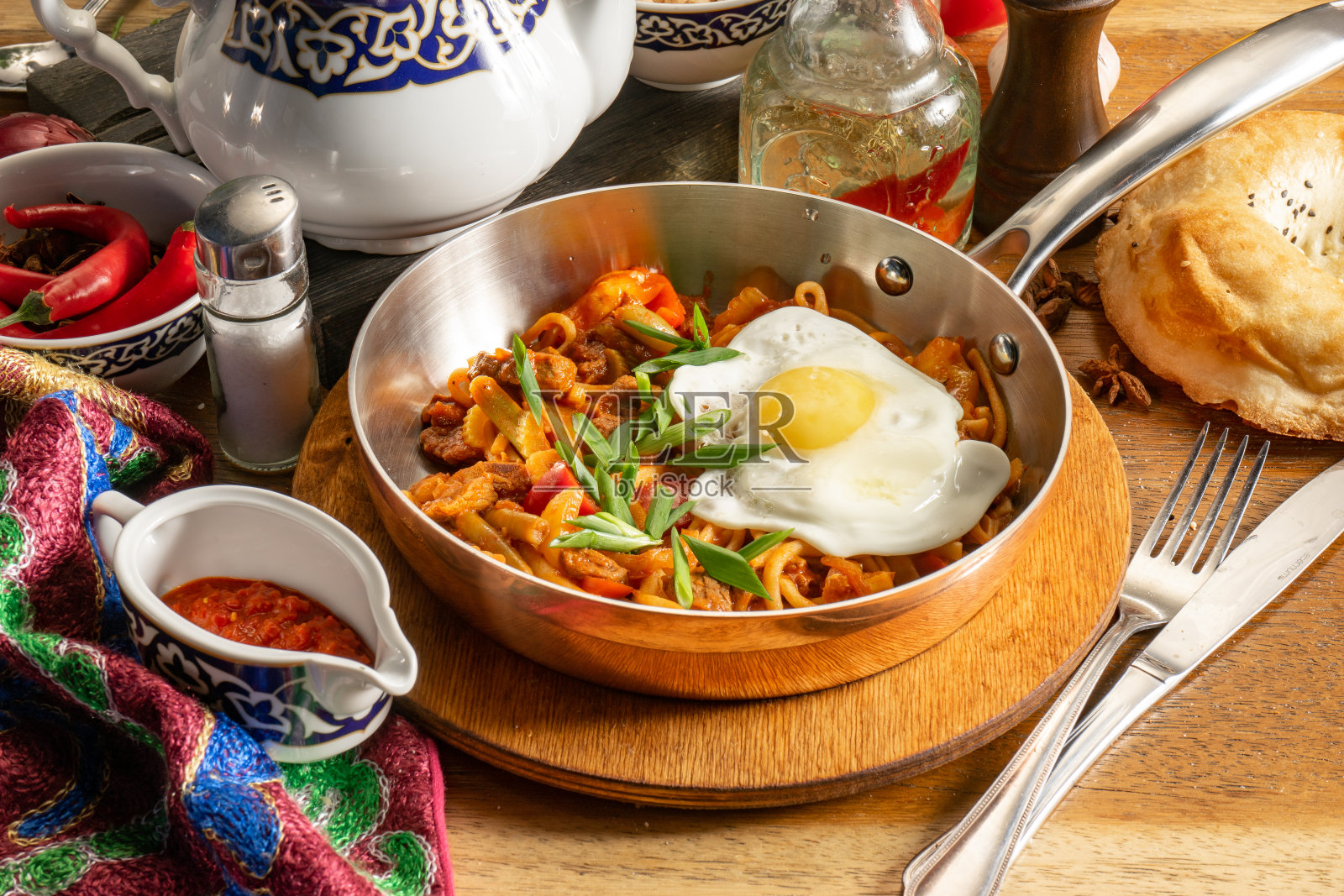 油炸lagman。羊肉、蔬菜、鸡蛋和adjika炒面。照片摄影图片