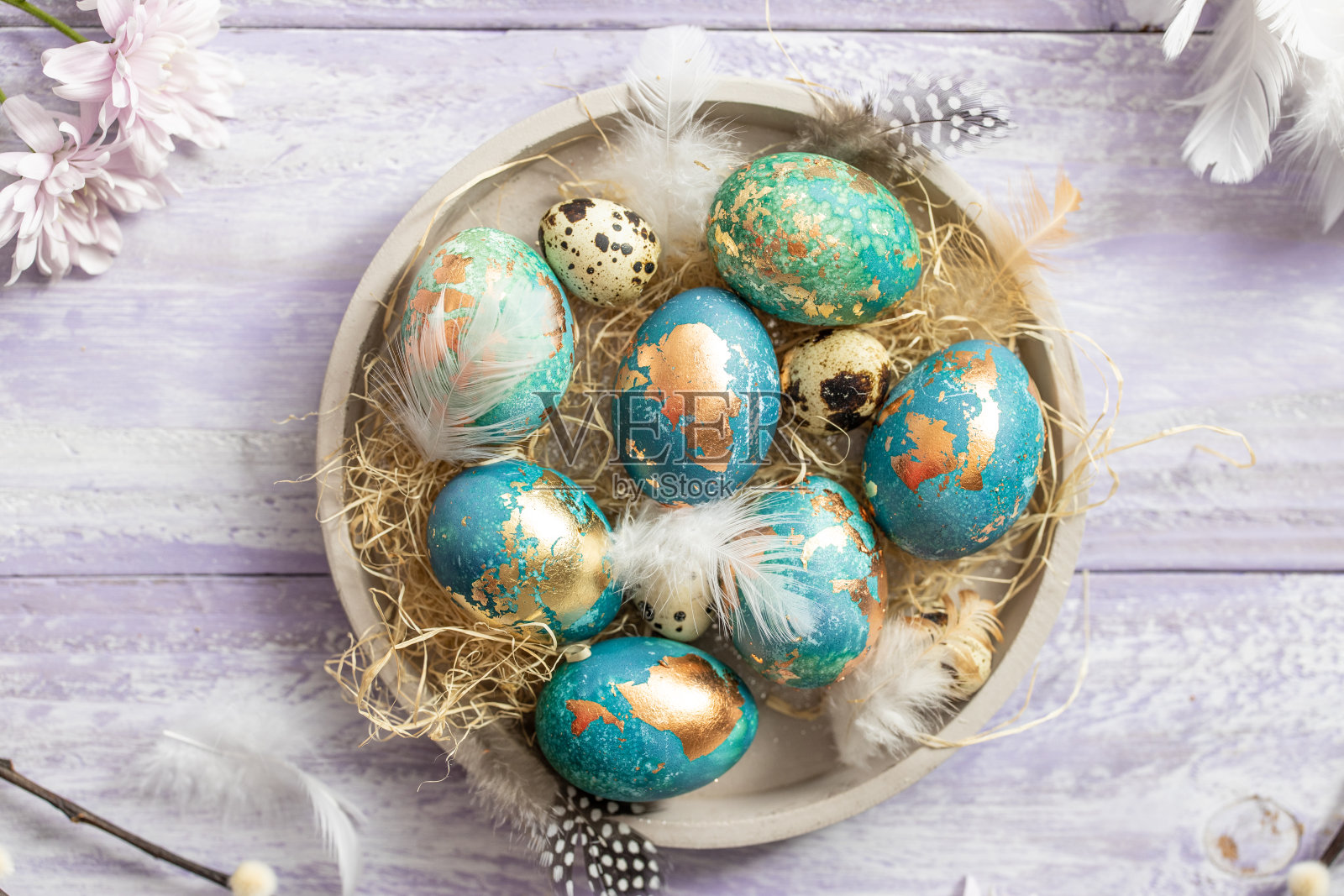 紫色的木头桌子背景上放着蓝色的复活节彩蛋照片摄影图片