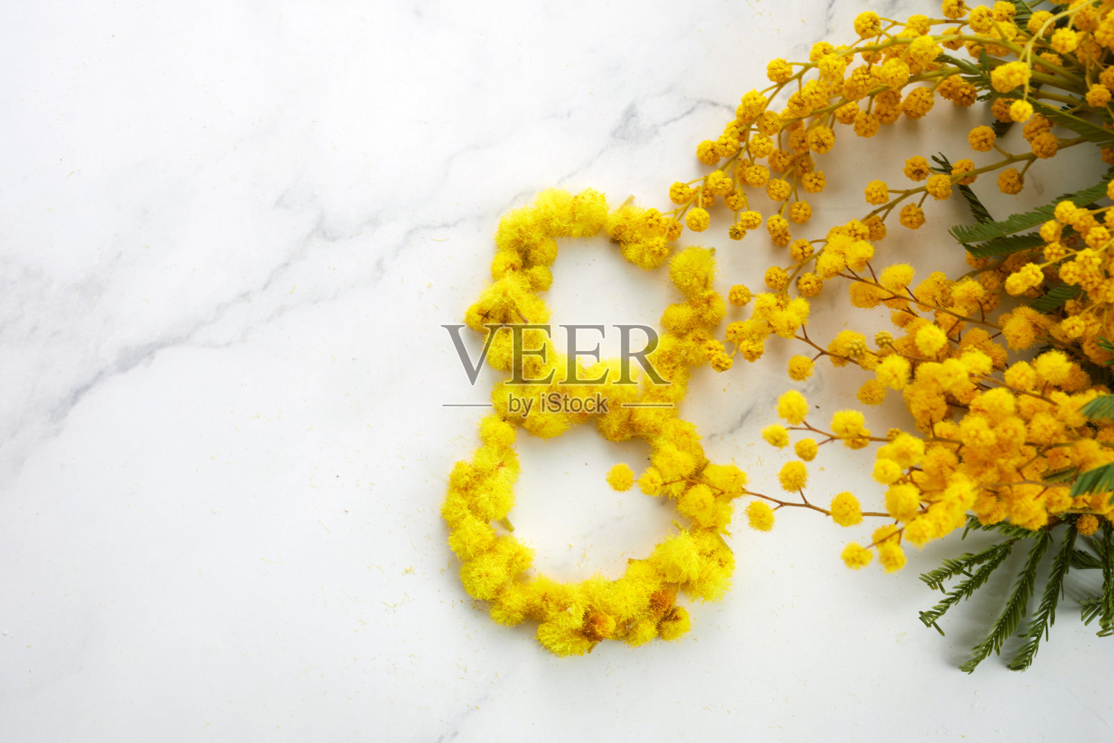 大理石背景上的一束黄色含羞草花。妇女节的概念。照片摄影图片