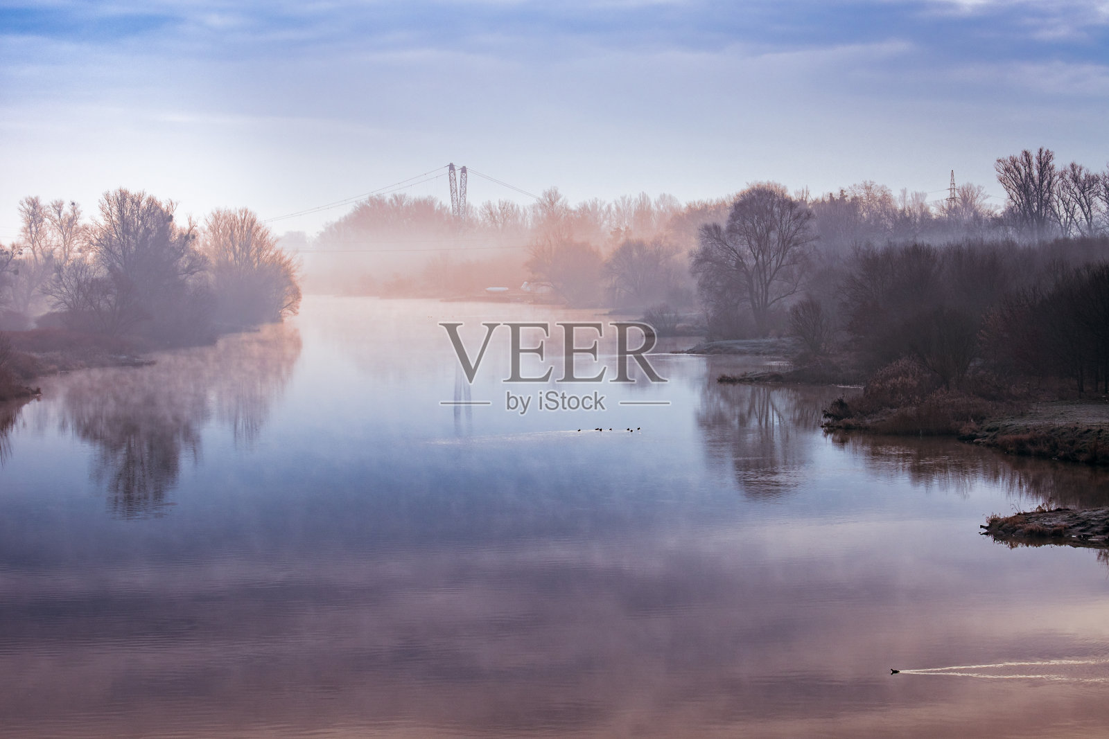 一个寒冷的早晨，弗罗茨瓦夫的奥德拉河上，一层薄雾浮在水面上。照片摄影图片