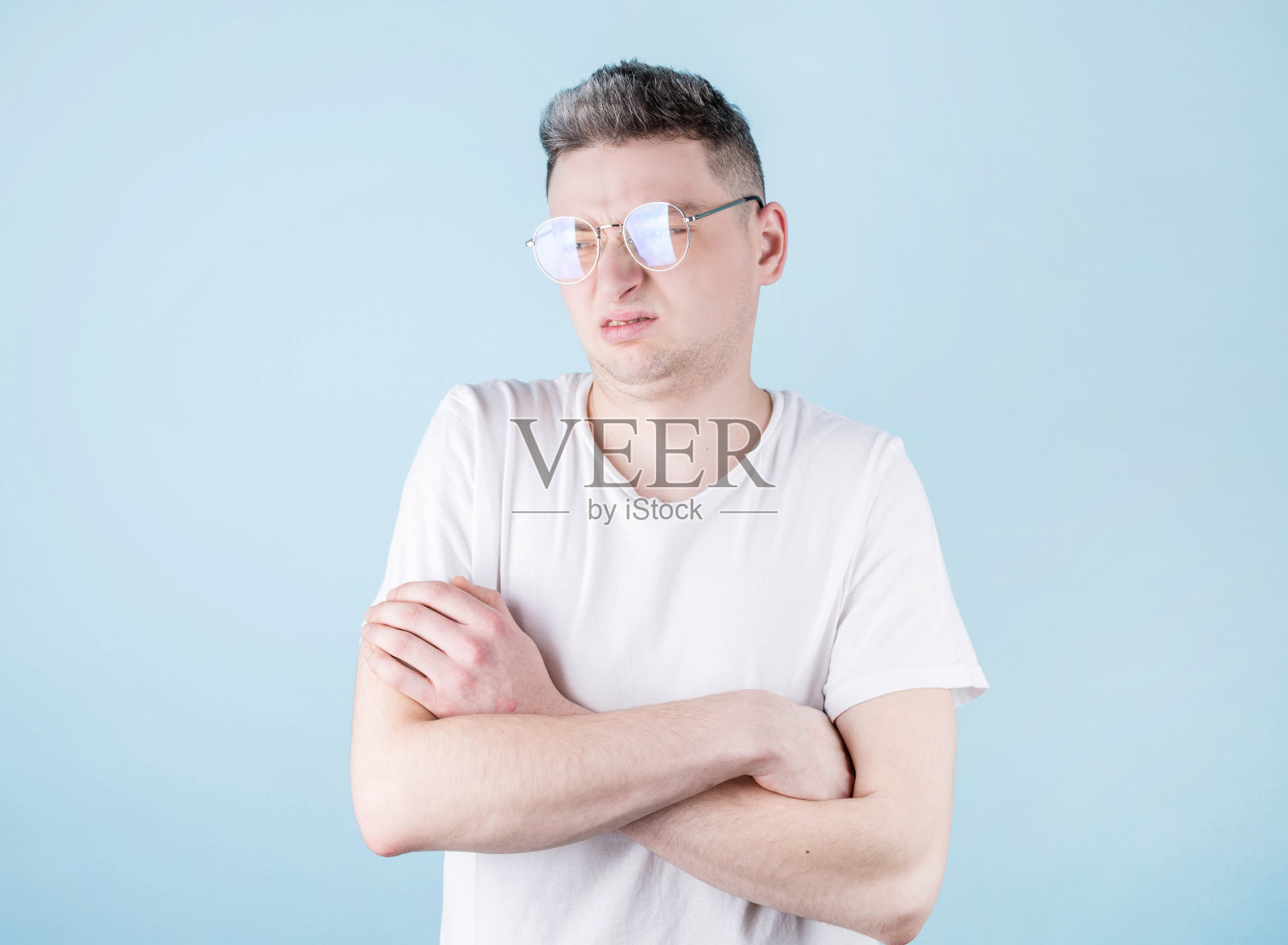 蓝色背景下的年轻人脸上露出厌恶的表情。消极情绪面部表情。照片摄影图片