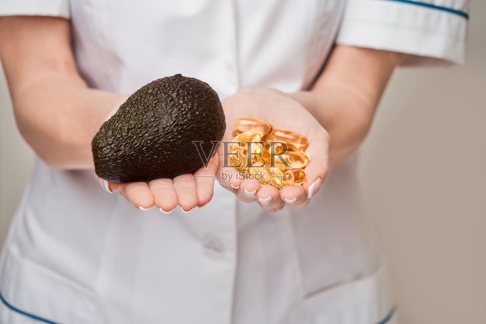 保健和饮食概念-医生营养学家或心脏病学家持有胶囊鱼油维生素D和omega-3脂肪酸和鳄梨照片摄影图片