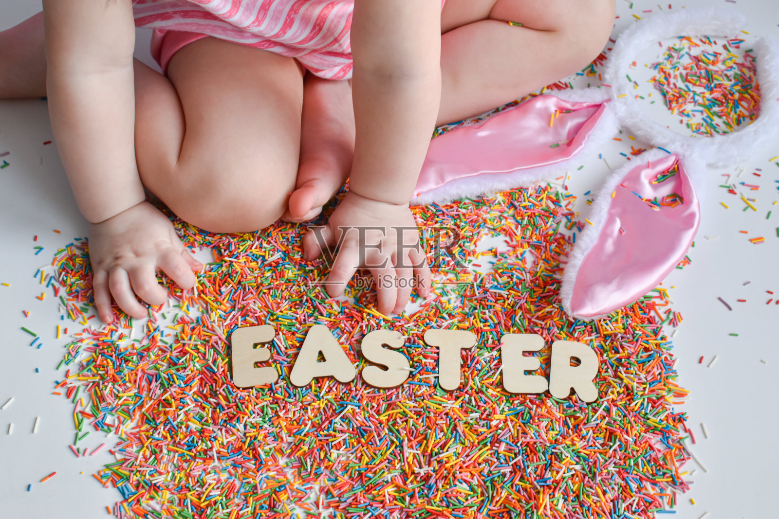 一个孩子的手伸向复活节这个词。用于糖果产品。复活节照片摄影图片