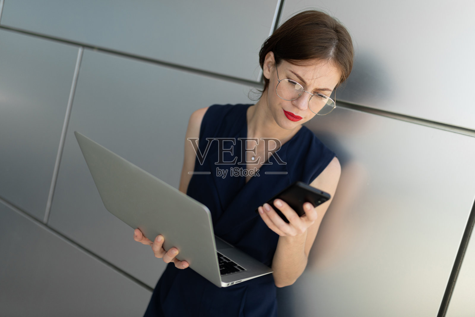 一位身着西装的女士在预约后拿着笔记本电脑站在外面照片摄影图片